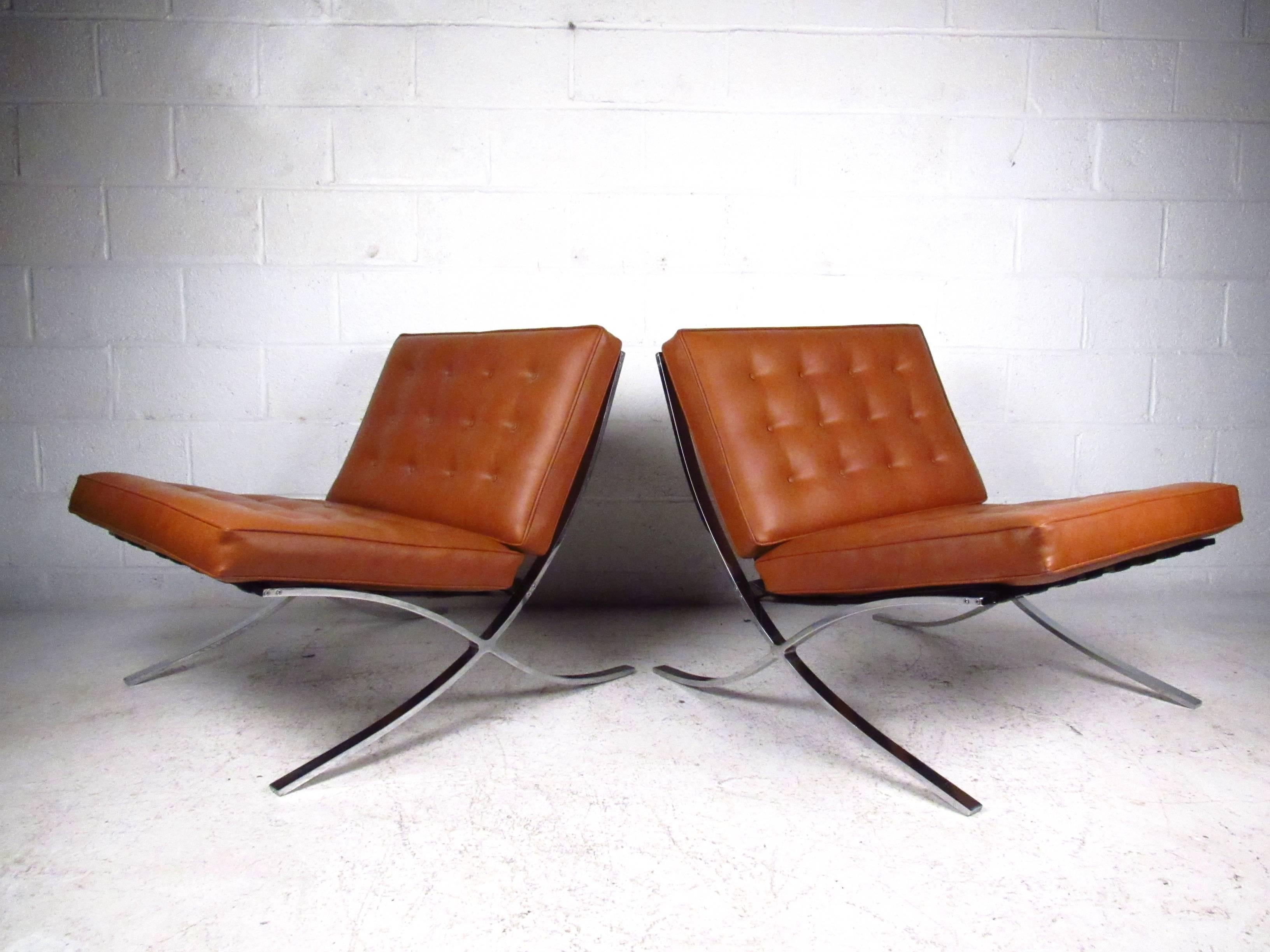 This beautiful pair of heavy chrome lounge chairs features the iconic style of Mid-Century master Mies Van Der Rohe. Tufted vinyl seats are in good condition, while strapped seat backs add to the comfort of the pair. Please confirm item location (NY
