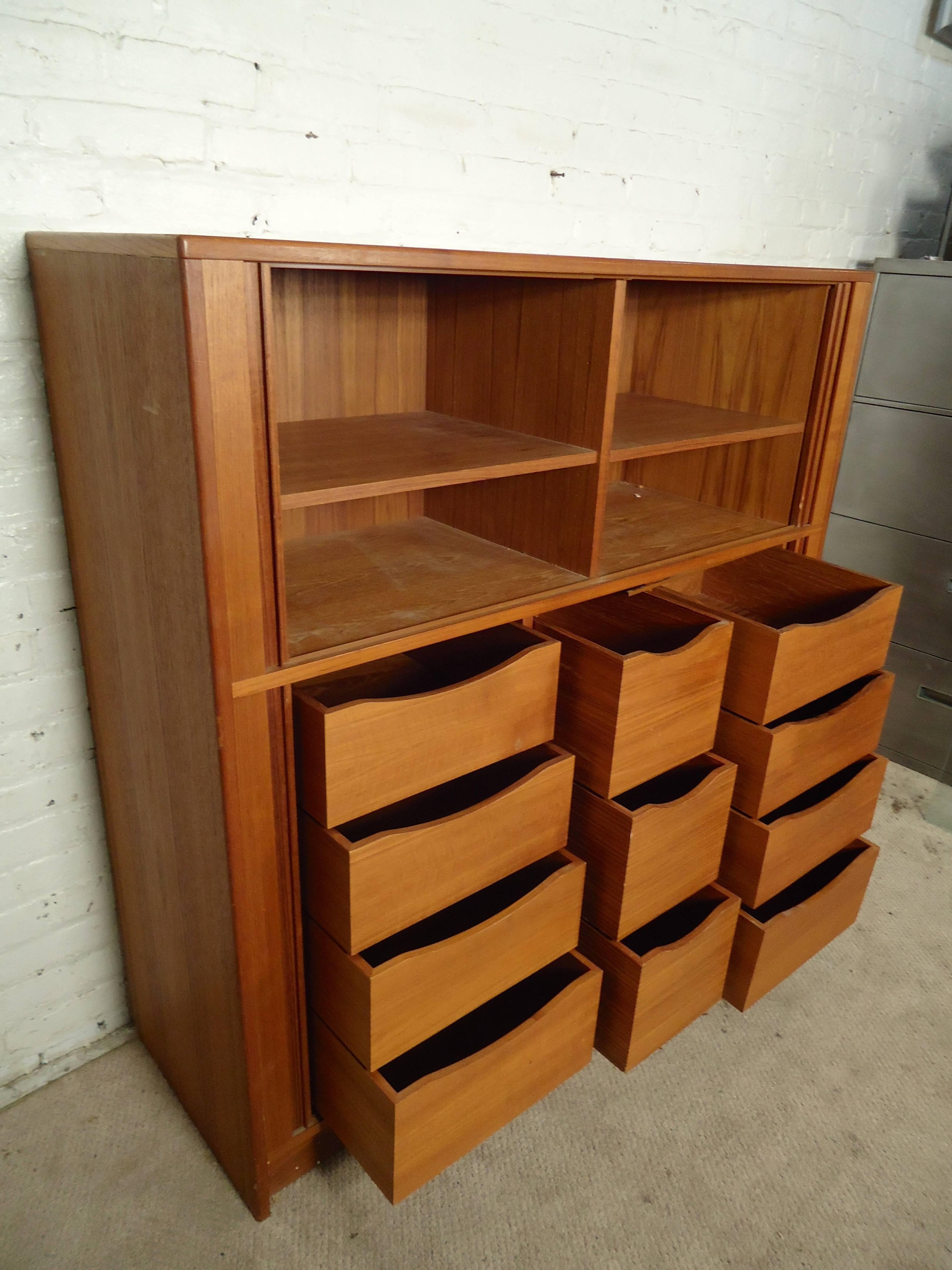 Mid-Century Modern cabinet with beautiful teak grain, featuring 11 drawers and top cabinet space. Four tambour doors recess inside the unit.

(Please confirm item location - NY or NJ - with dealer).
 