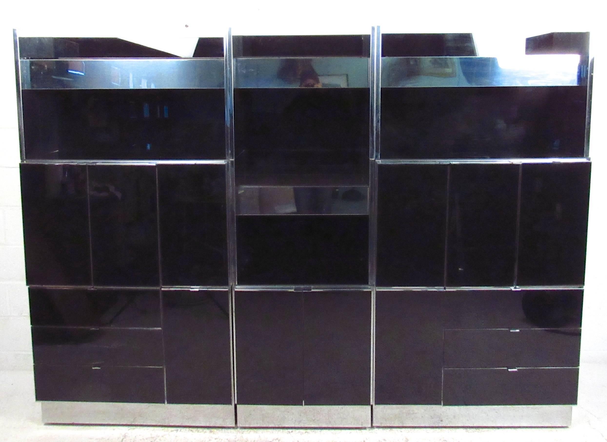 This unique black glass modular unit offers a substantial and spacious storage and display option for a variety of settings. Back lit display shelves, spacious cabinets, and plenty of drawers provide stylish organization options for home or office.