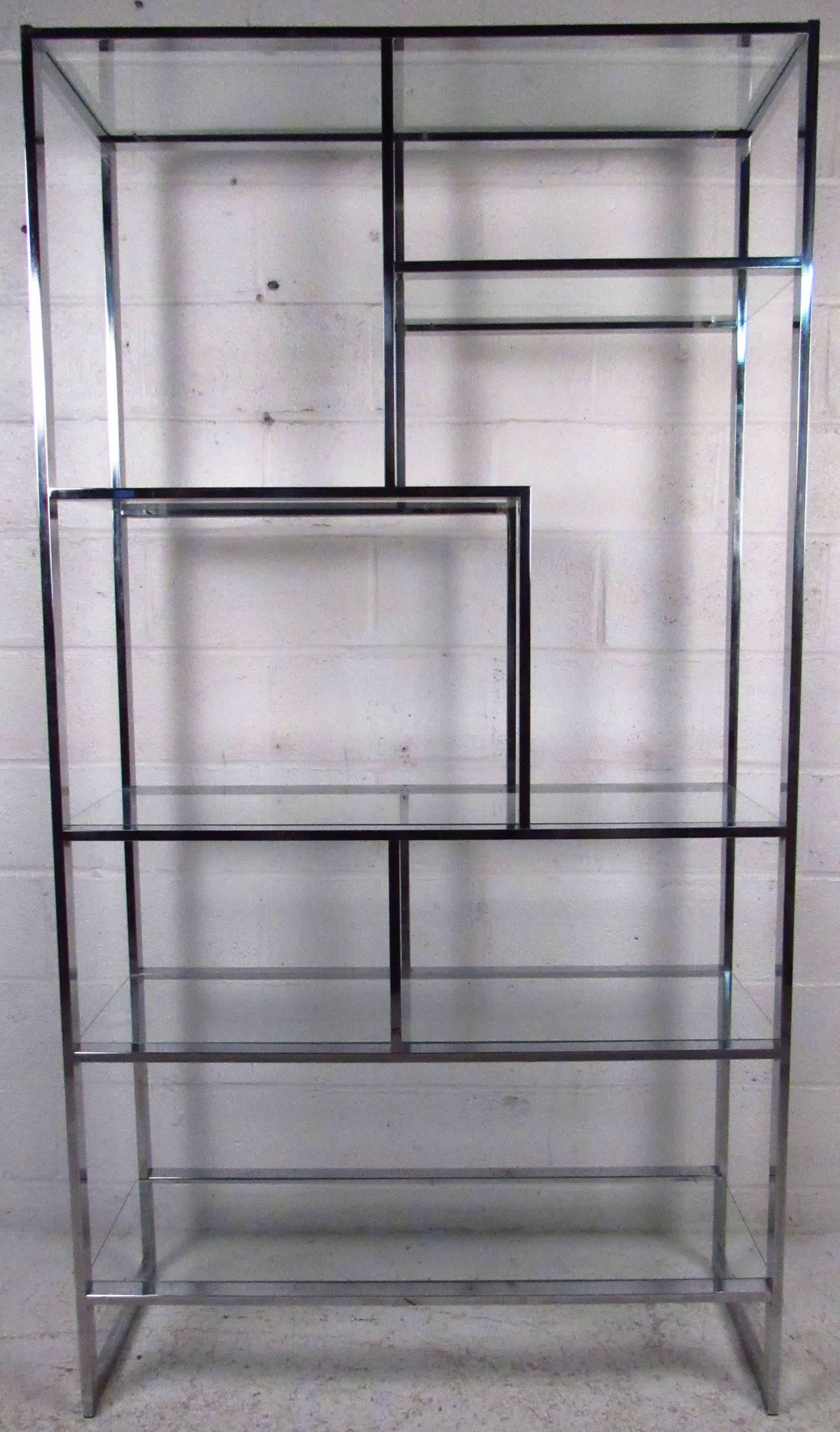 Vintage modern étagère featuring sculpted chrome body with glass inserts, designed by Milo Baughman. Ideal midcentury shelf unit for home or store display, this quality vintage shelf display adds an elegant 1960's statement to an interior. Please