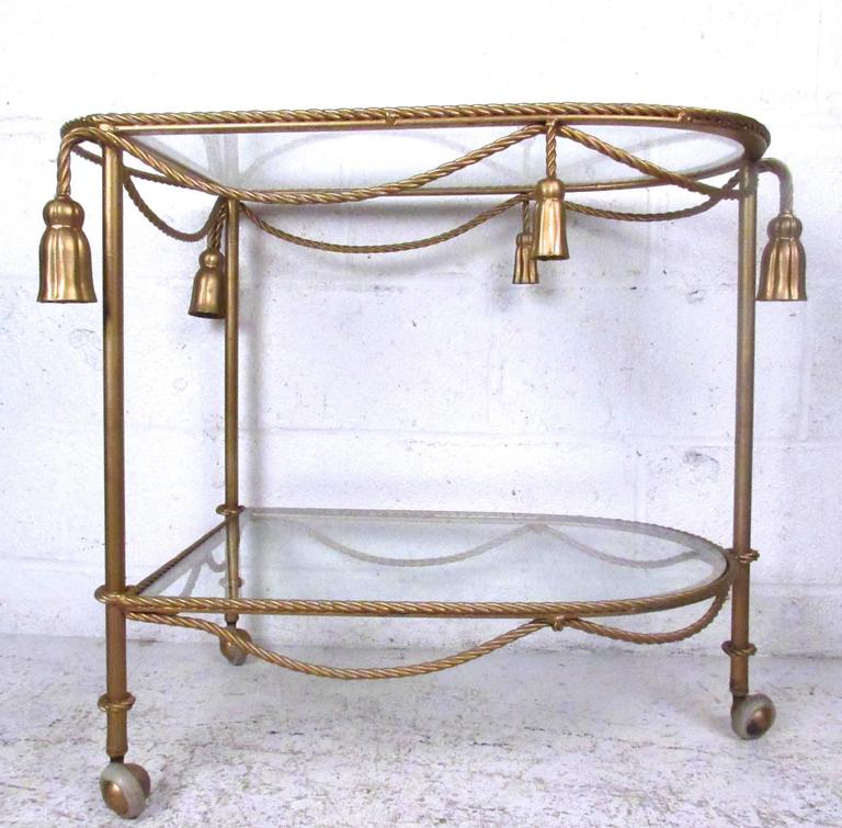 This vintage gold painted service cart is perfect for use as a bar cart or unique display table. Ornate braided rope detail adds to the timeless style of the piece. Please confirm item location (NY or NJ).