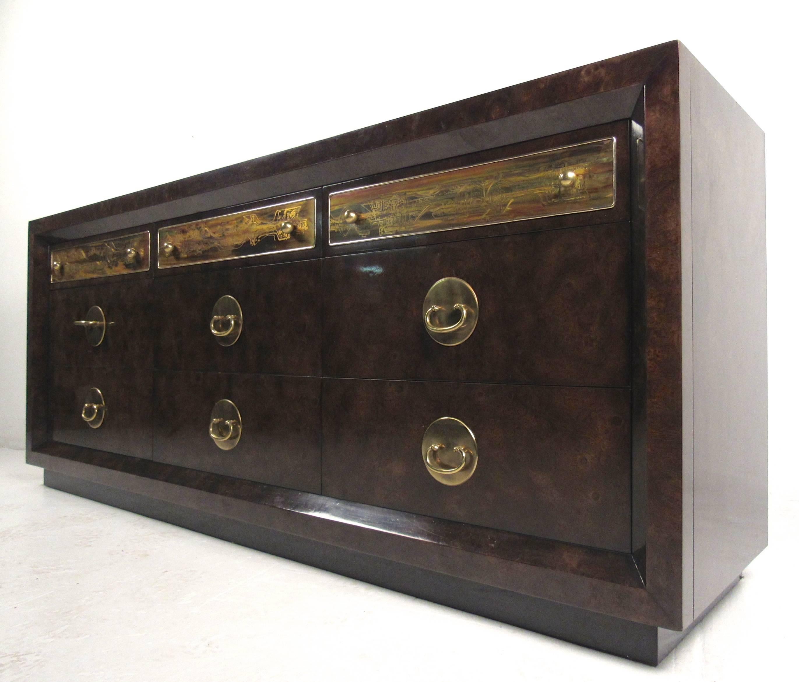 This Mastercraft dresser features acid-etched designs, unique brass pulls, and quality vintage construction. Wonderful burl wood finish adds to this stylish storage piece, making it a unique addition to any interior. Please confirm item location (NY