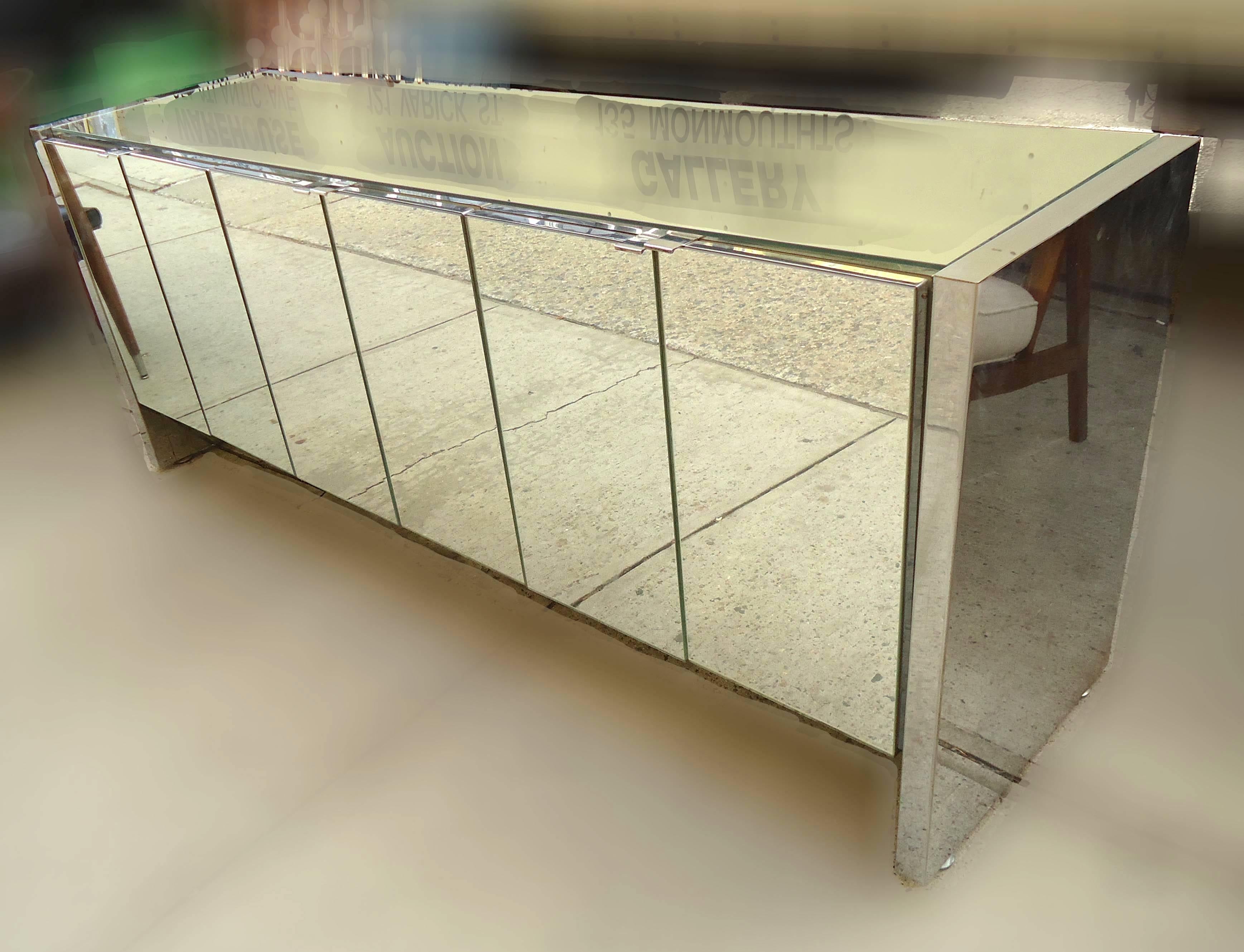 Chic Mid-Century mirrored sideboard with three two-door cabinets. Adjustable or removable shelves, mirrored glass and polished chrome handles.

(Please confirm item location - NY or NJ - with dealer).
 