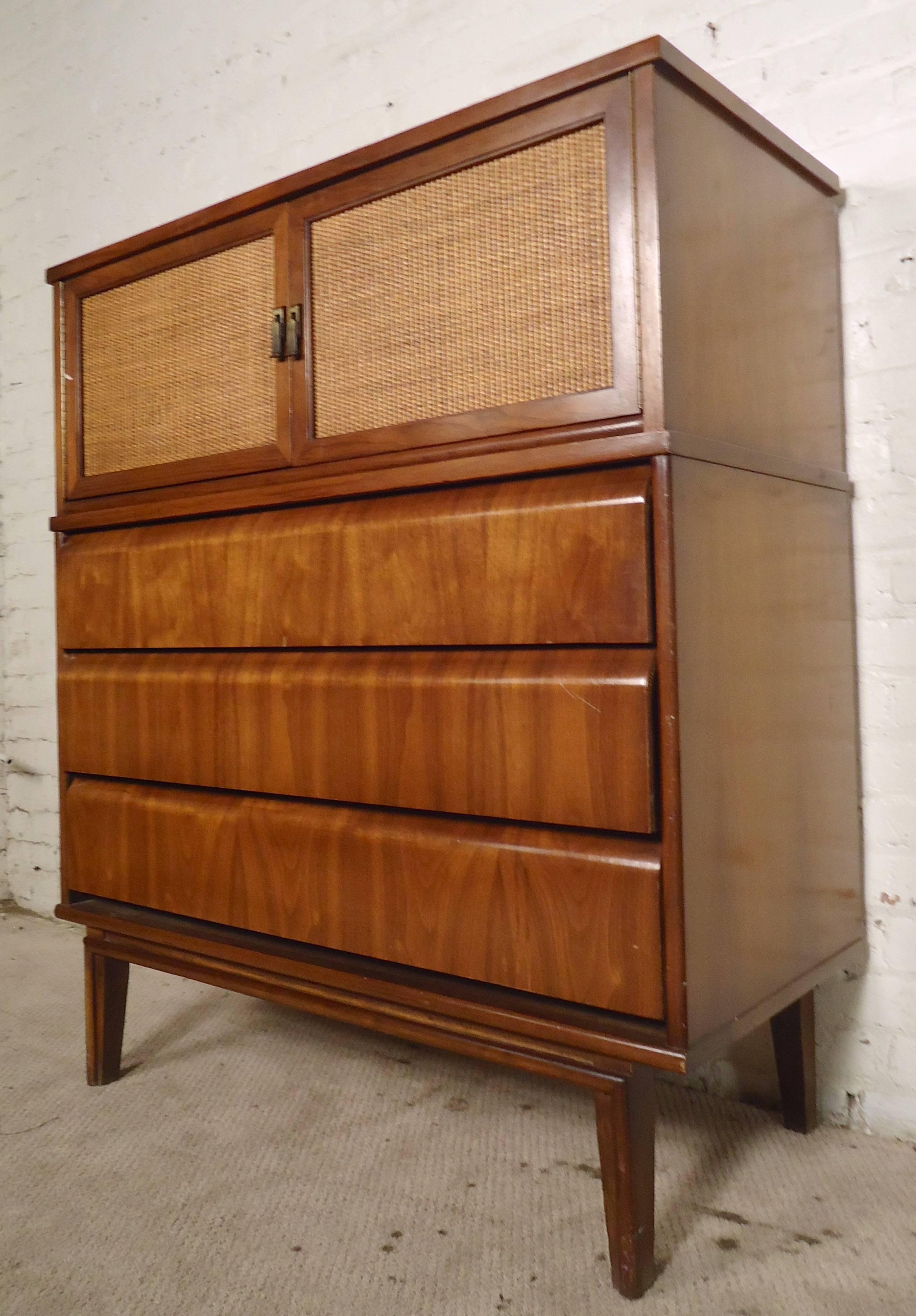 Mid-century modern chest of drawers with cane doors and curved drawers. Five total drawers, three with unusual formed tops and two set inside cane doors. Warm walnut grain throughout with brass pulls.

(Please confirm item location - NY or NJ -