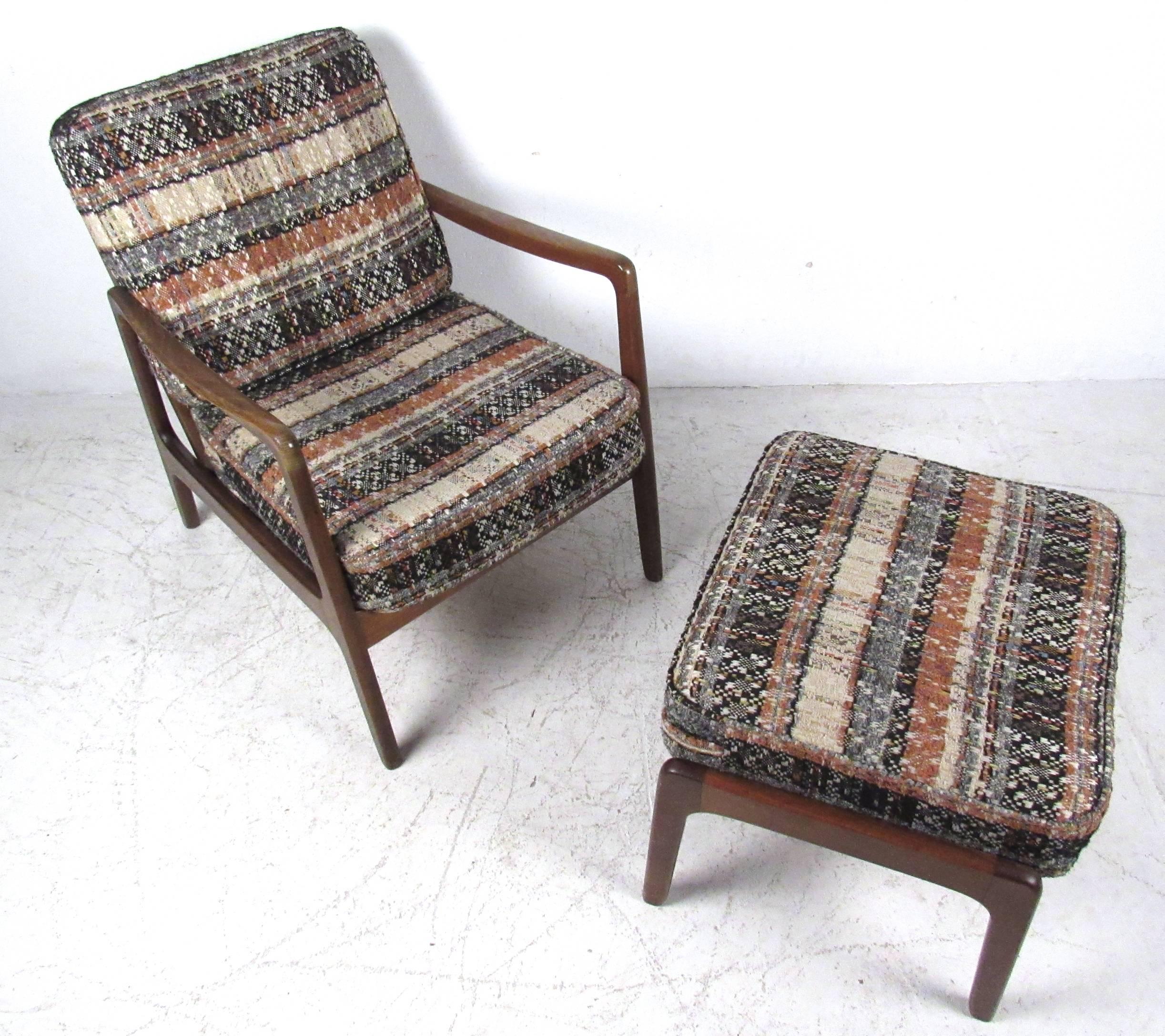 This slat back walnut lounge chair by Ole Wanscher for John Stuart comes complete with ottoman and flannel style tweed cushions. Stylish sculpted armrests accent it's comfortable design, adding to this Mid-Century marriage of style and usability.