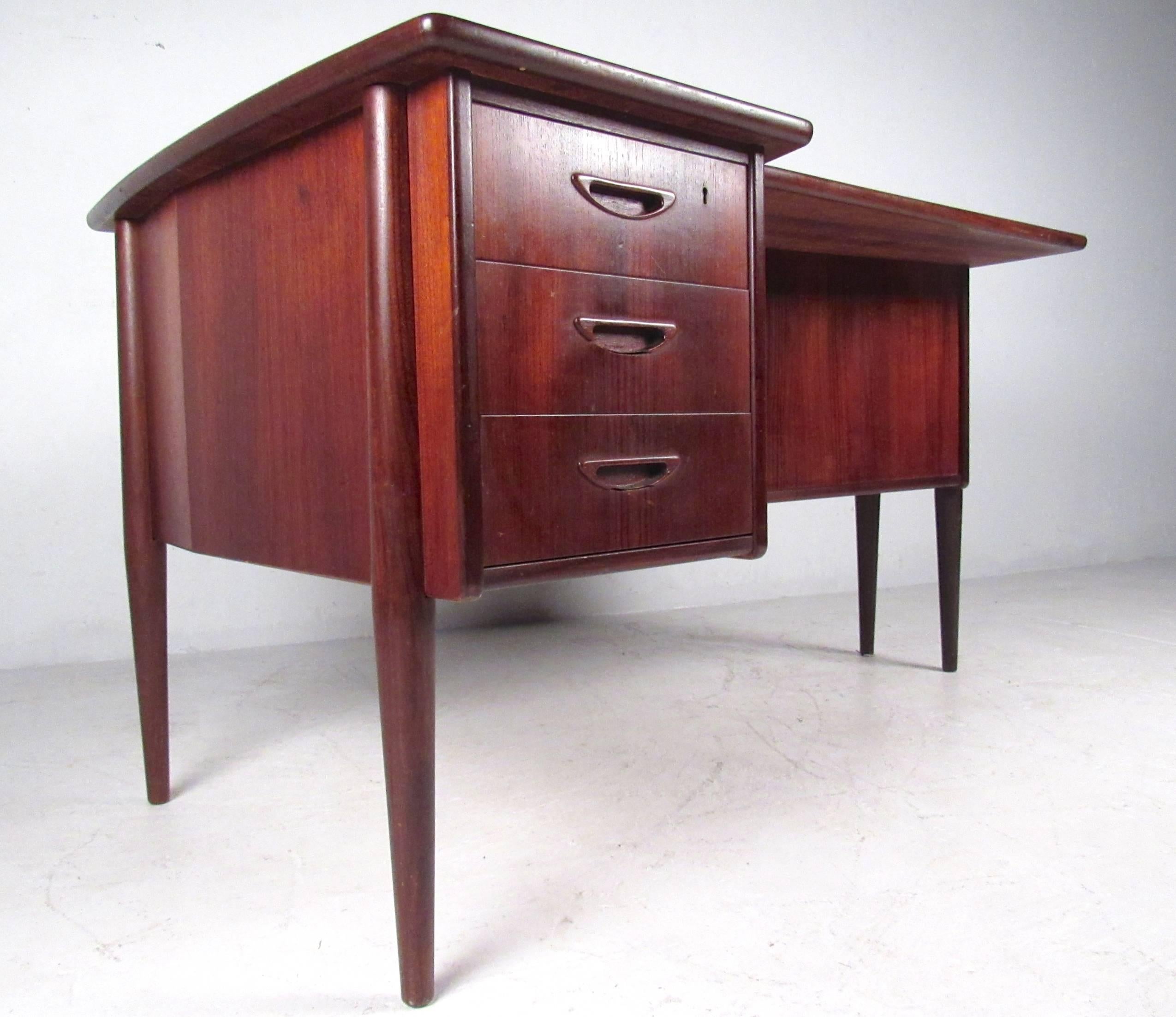 This stylish vintage desk features three drawers for storage and a cutaway style desktop. Natural wood grain finish, raised edges, tapered legs, and additional storage on the desks rear panel make for the perfect mix of storage, style, and usable