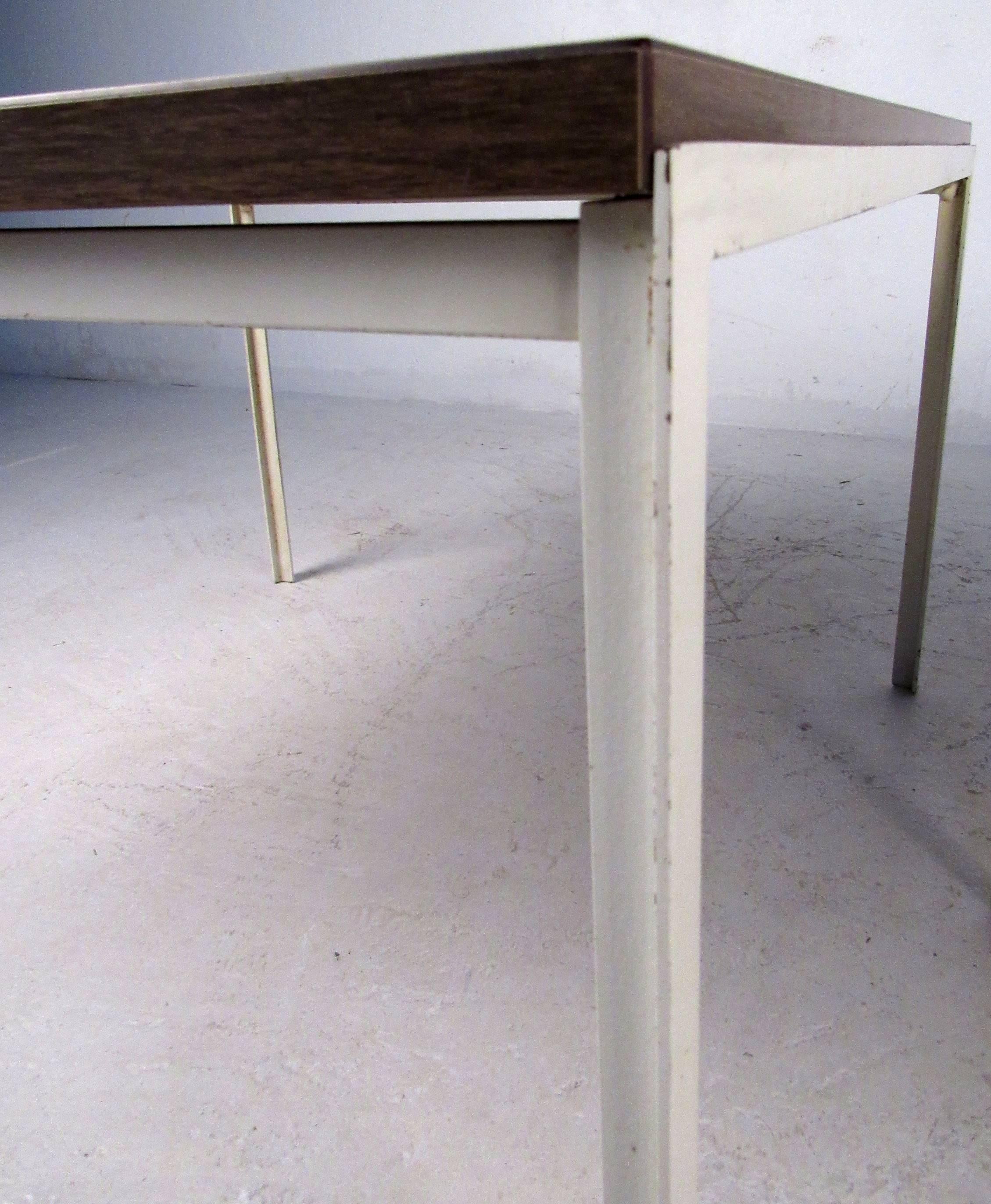 Two vintage-modern side tables featuring sleek design with Formica wood finish to top and metal base. Manufactured by Knoll.

Please confirm item location NY or NJ with dealer.