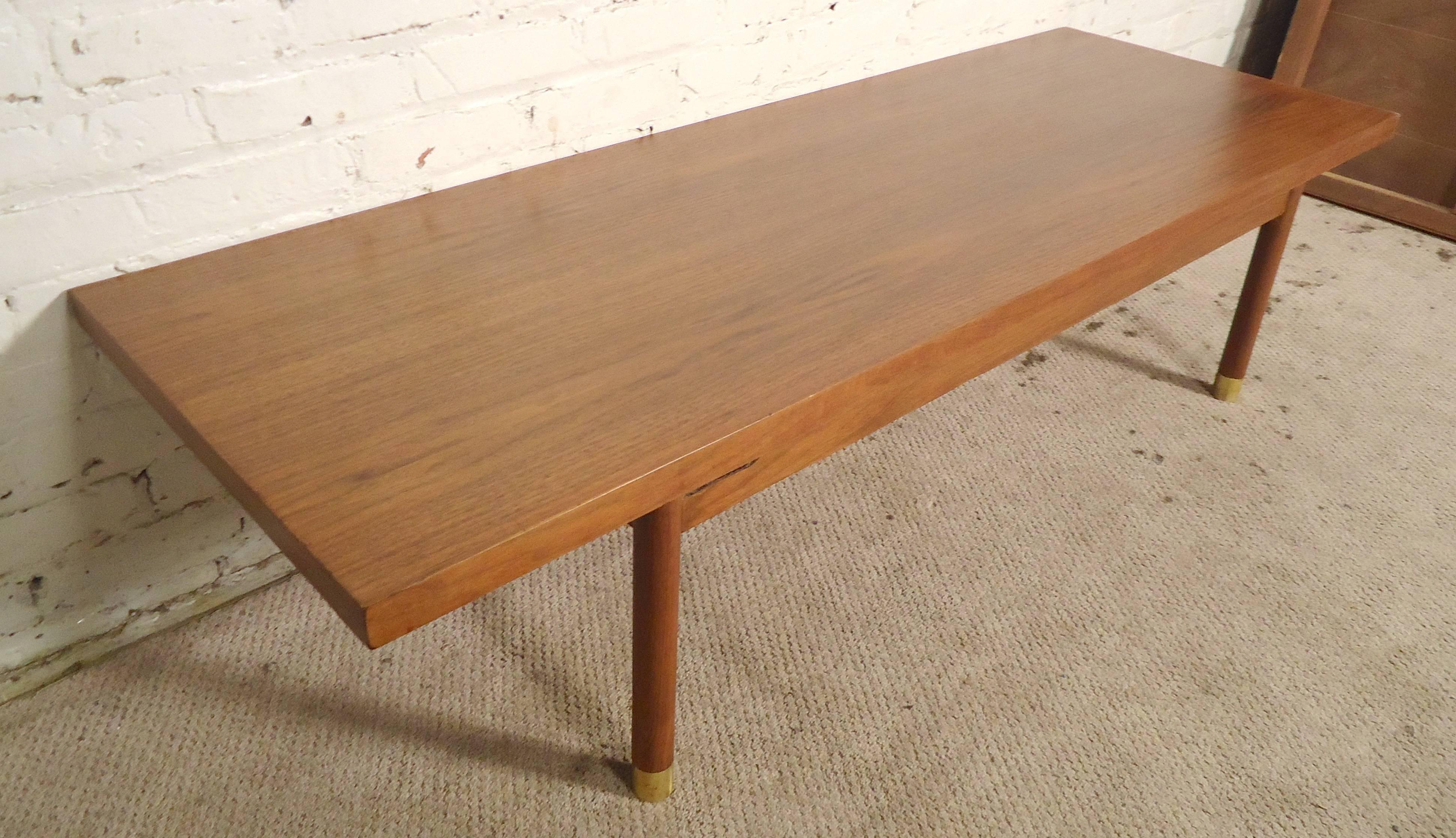 Midcentury table with warm walnut grain. Long top, round legs with brass caps.

(Please confirm item location - NY or NJ - with dealer).
  
