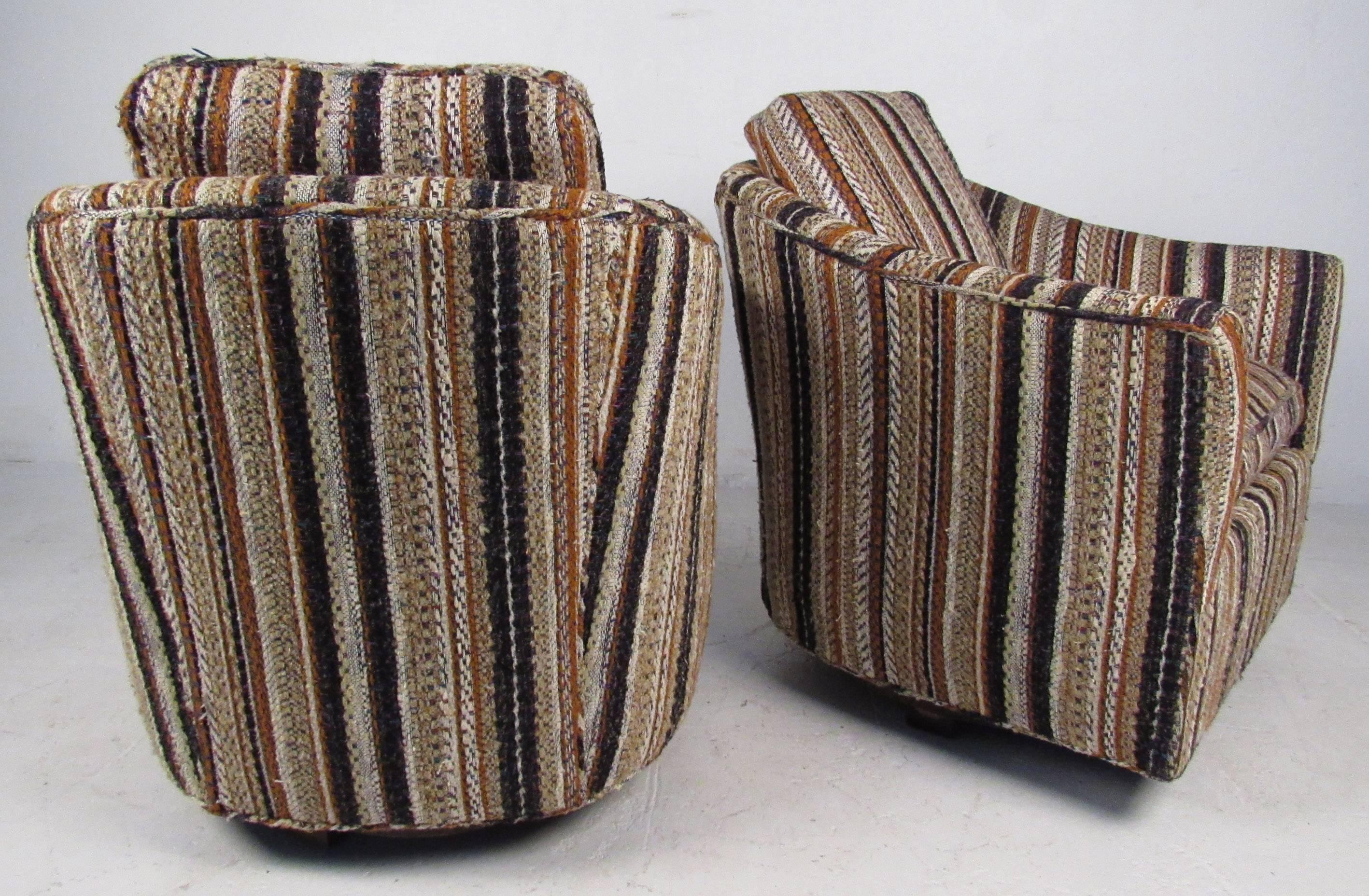 Pair vintage-modern lounge chairs featuring swivel base with striped tweed upholstery and removable cushions. Striking mid-century addition to home or business seating arrangements, this barrel back pair combine retro style with timeless comfort.