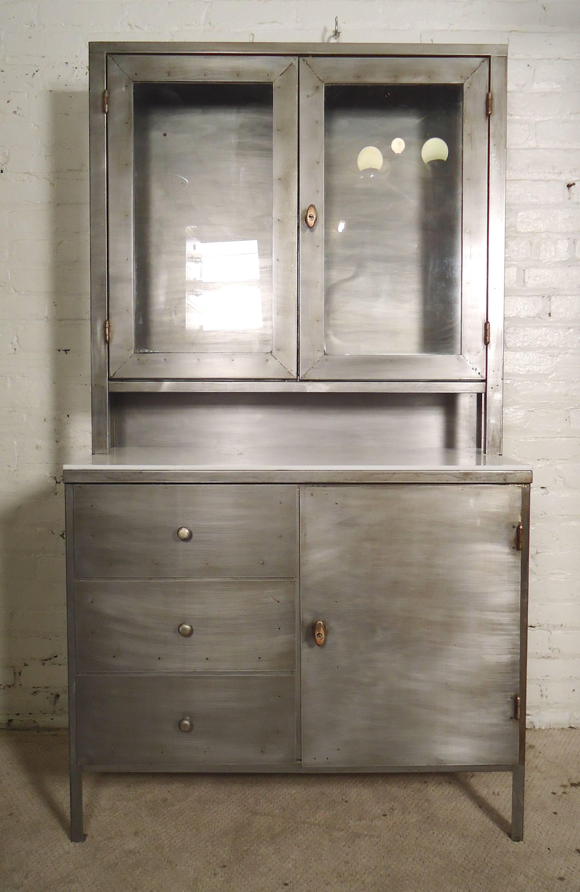 Industrial metal stacked cabinet, restored in an attractive bare metal style finish. Top glass cabinet allows for displayed storage while the bottom has drawers and cabinet space. 

(Please confirm item location - NY or NJ - with dealer)
