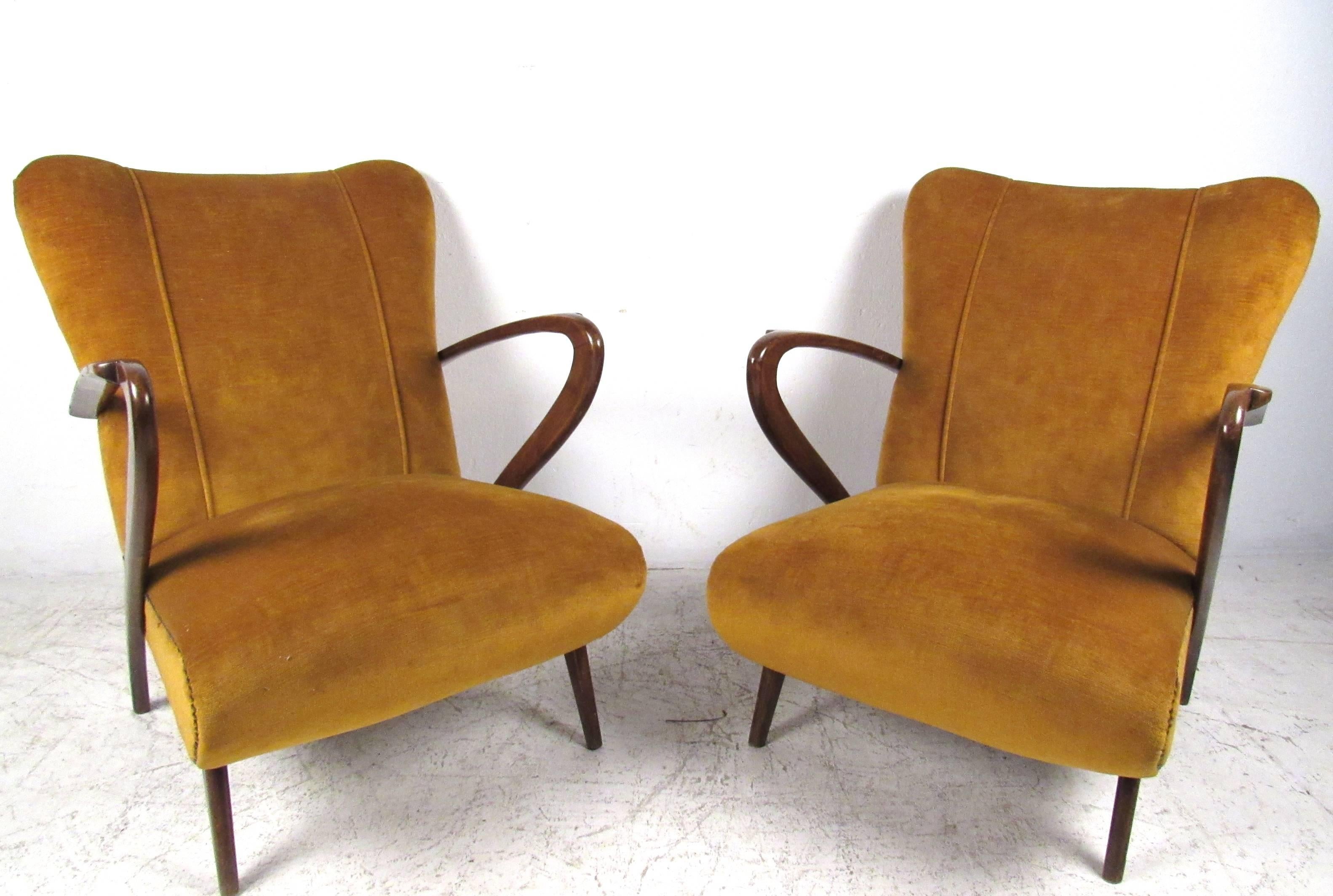 This matching pair of vintage armchairs features exquisite sculptural arms, tapered legs, and the contoured seats that effortlessly combine style and comfort. Please confirm item location (NY or NJ). 