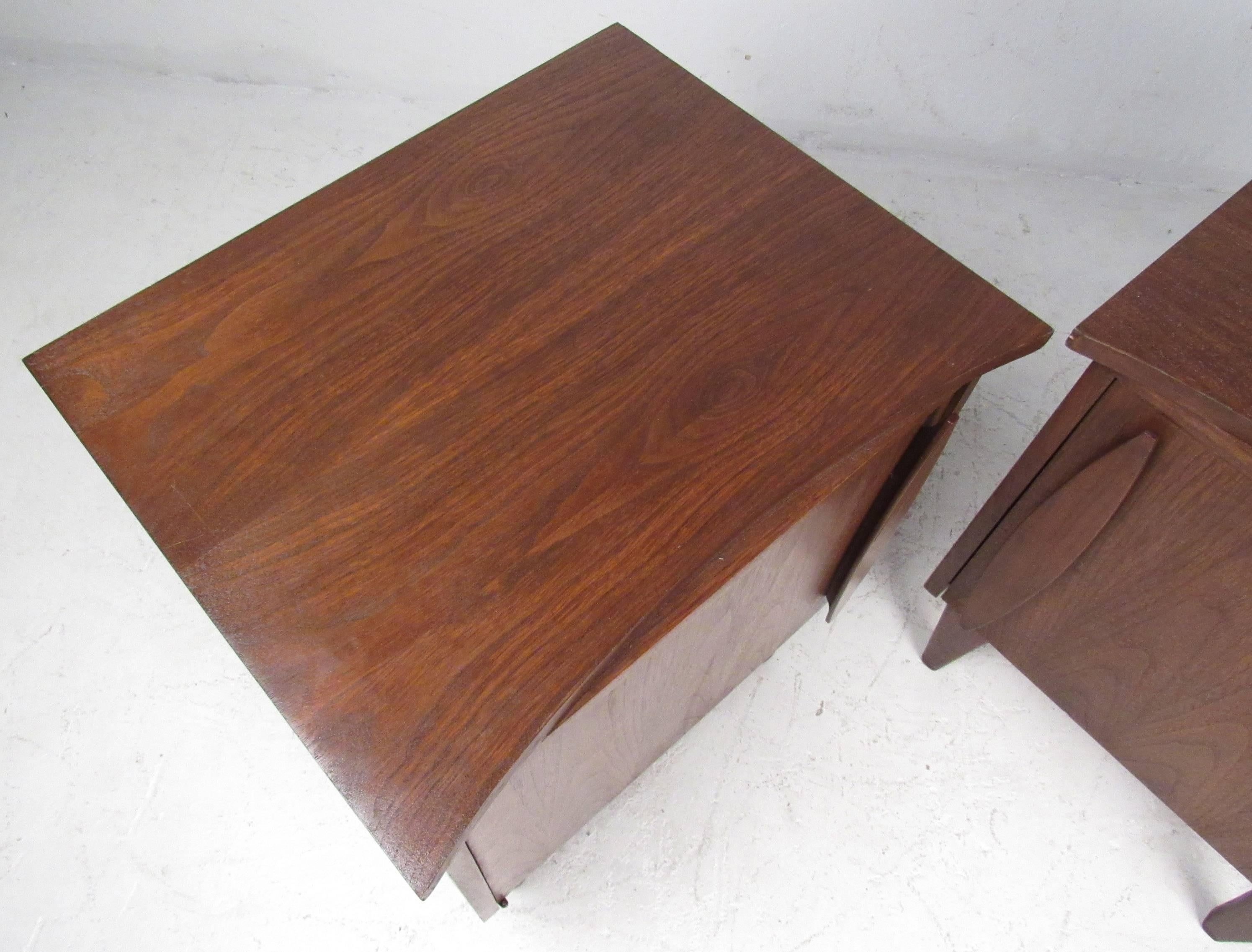 Vintage-modern pair of nightstands each featuring single door with sculpted handle and one interior shelf. Sculpted handles and rich walnut finish add to the midcentury appeal of this piece.

Please confirm item location NY or NJ with dealer.