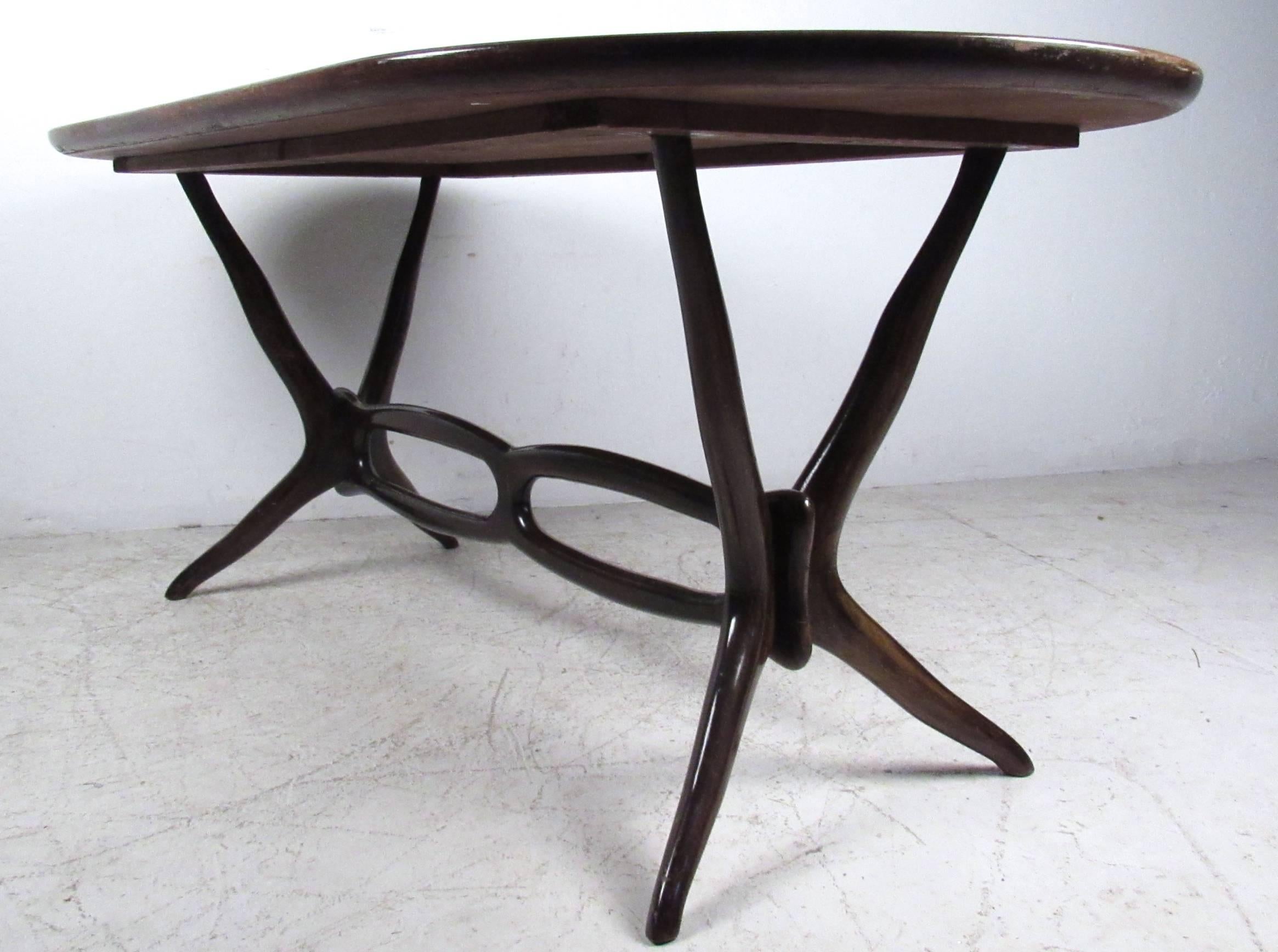 This unique dining table features unique vintage lucite top, sculptural stretcher and tapered legs. Elegant yet inviting this impressive Mid-Century table is well suited to a multitude of settings, please confirm item location (NY or NJ).