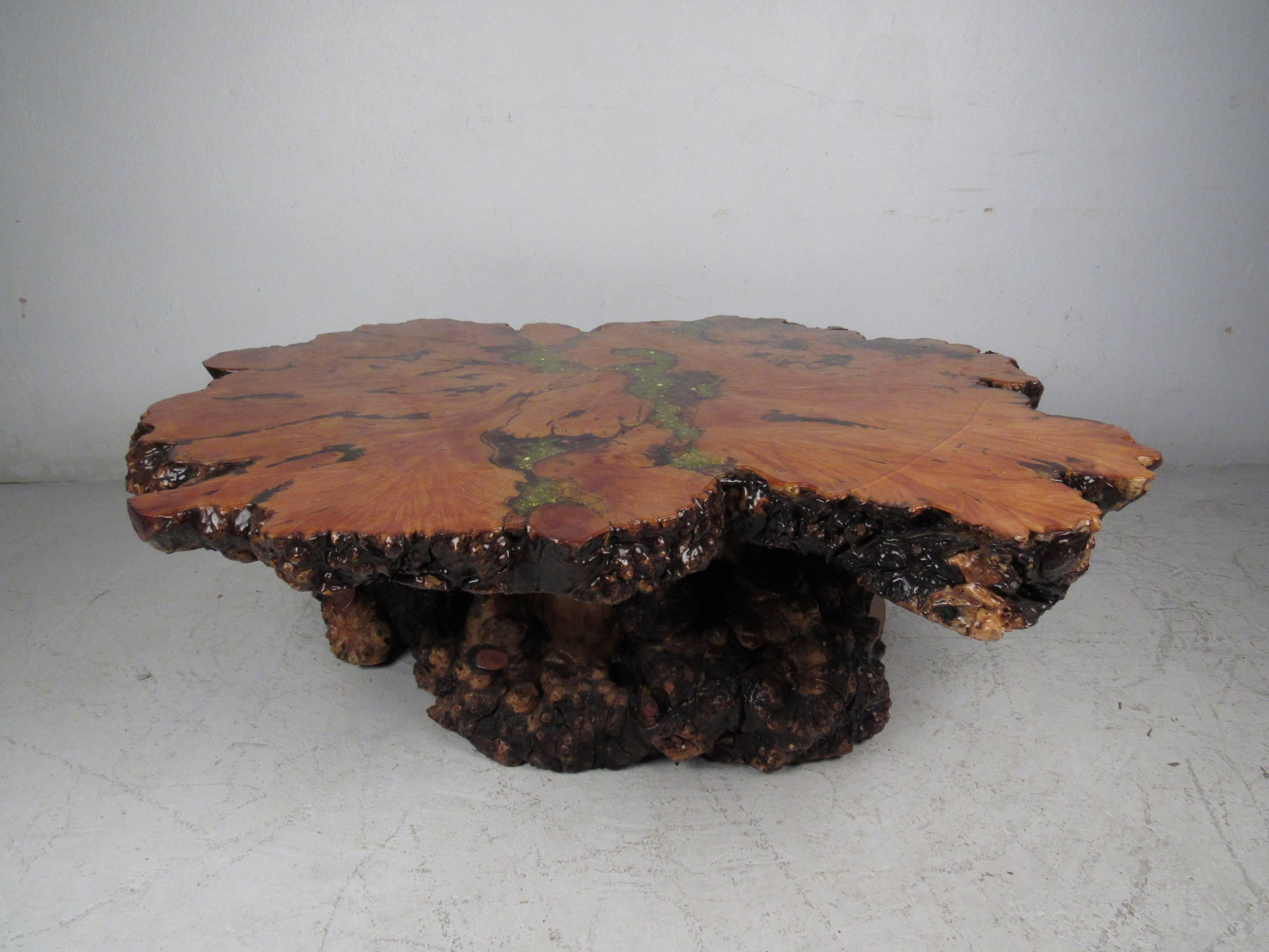 This beautiful vintage tree slab coffee table has pockets filled with specimen minerals and a thick resin finish. An unusual live edge top, intertwining root base, and elaborate colors make this piece the perfect addition to any modern interior.