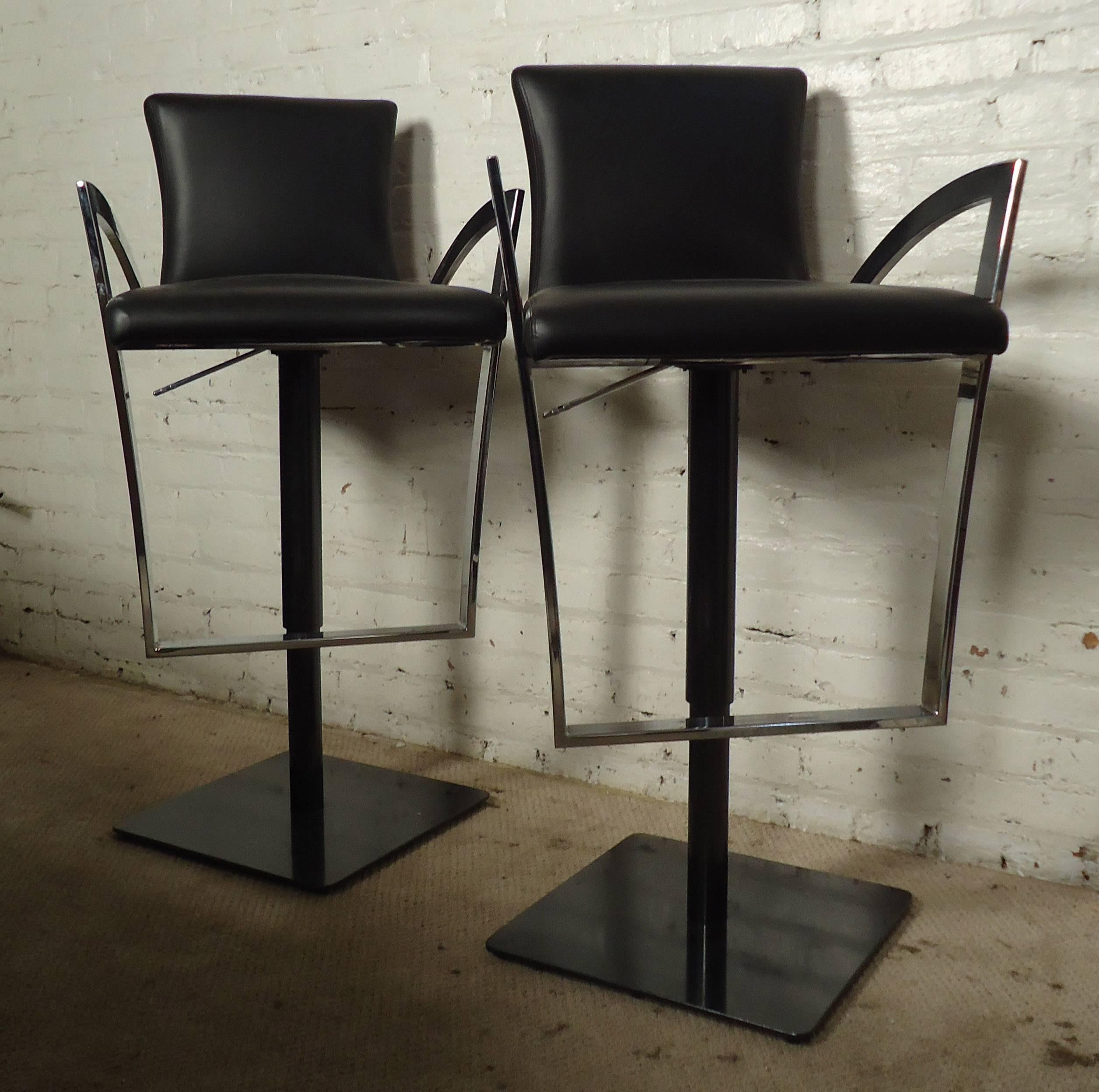 Two stools featuring leather upholstery, sculpted chrome arms, and sturdy metal base with adjustable height 25 - 30 inches; four stools are available, price is for one pair.

Please confirm item location NY or NJ with dealer.