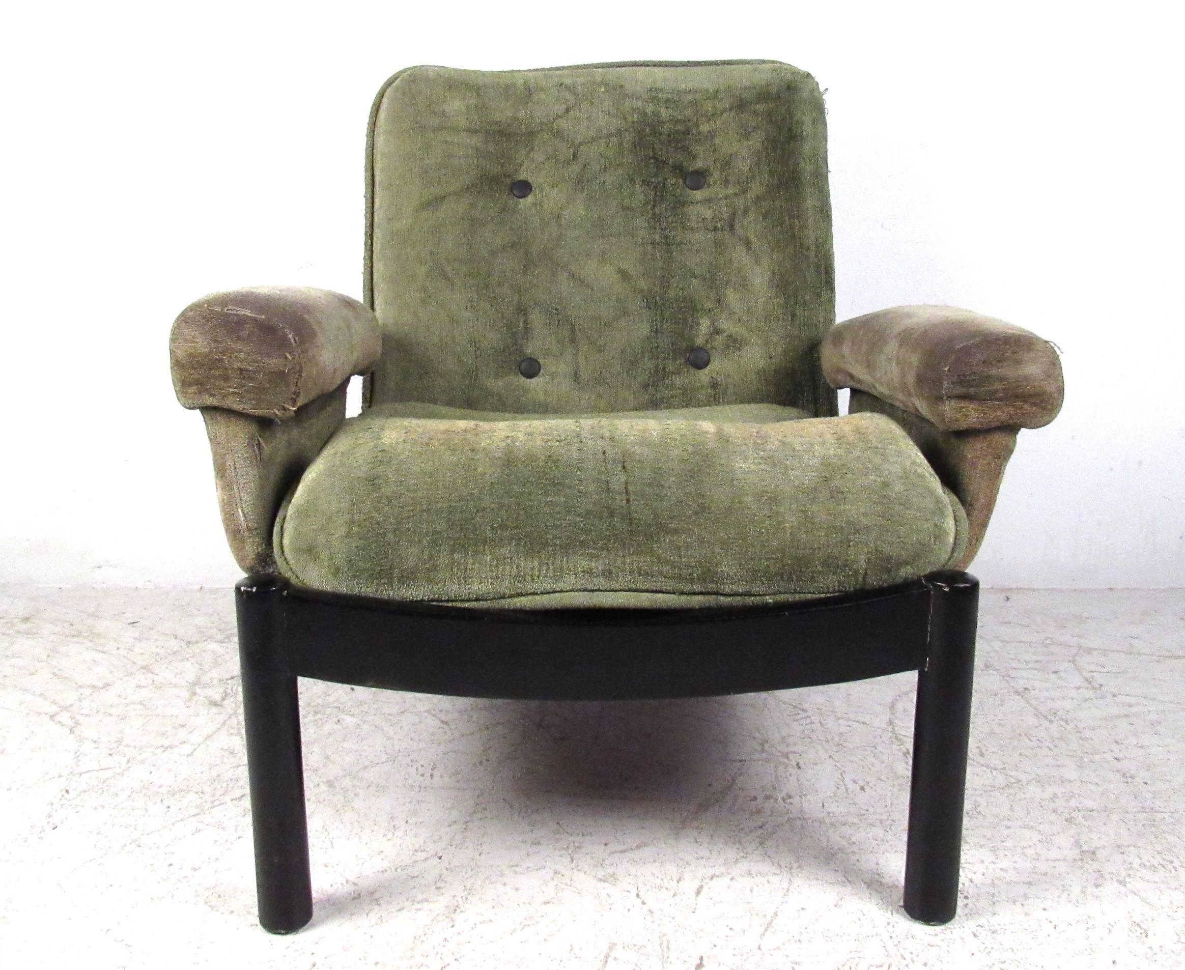 This uniquely designed vintage chair features a low slung style, complete with upholstered armrests, black lacquered frame,  and tufted seat back. Wide seat and plush seat back make this a comfortable addition to seating in any situation. Please