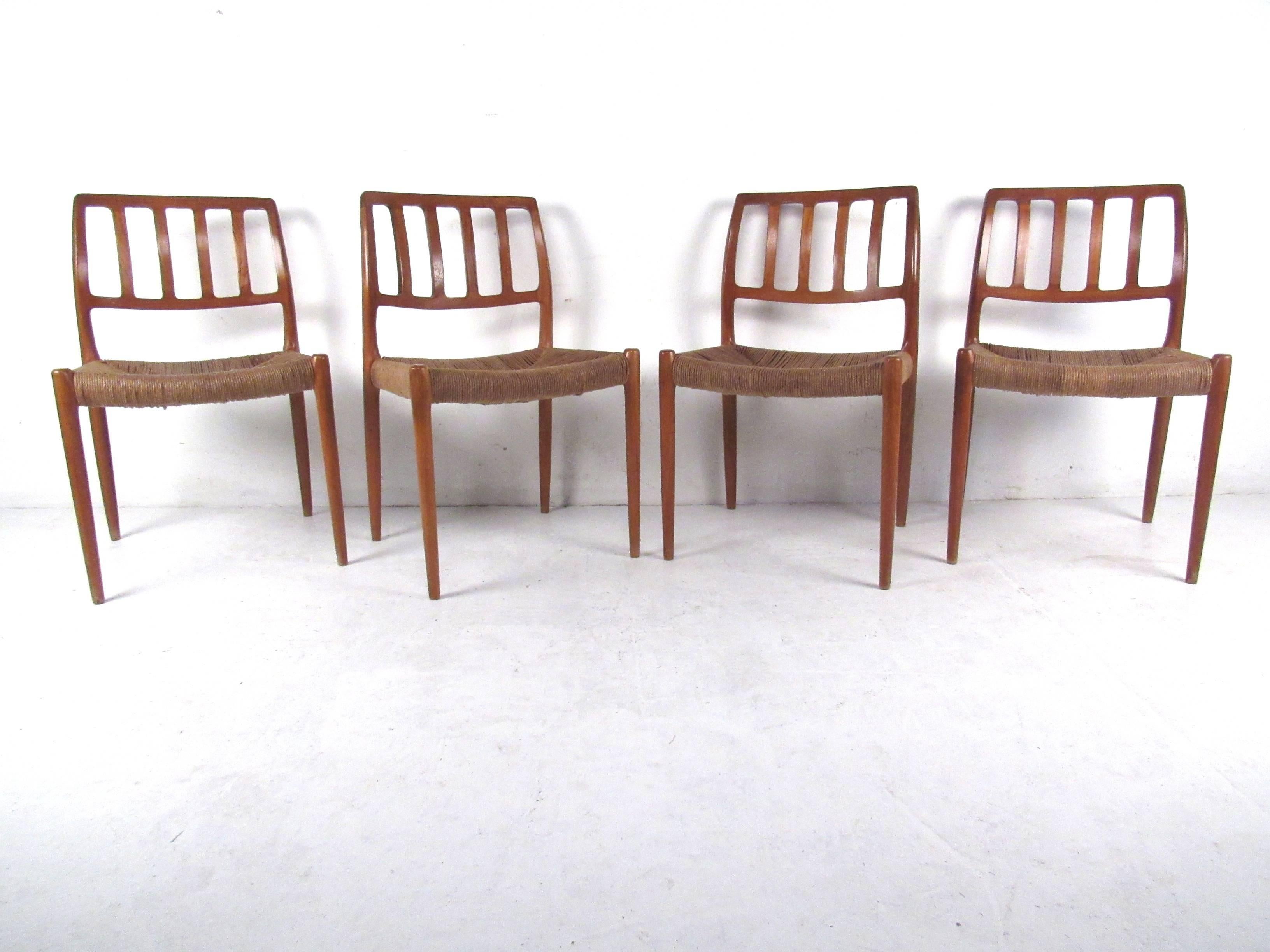 This gorgeous set of four dining chairs designed by N.O. Møller features woven rush seats and unique sculpted backs. These beautiful chairs make an impressive statement in any setting. Please confirm location (NY or NJ).