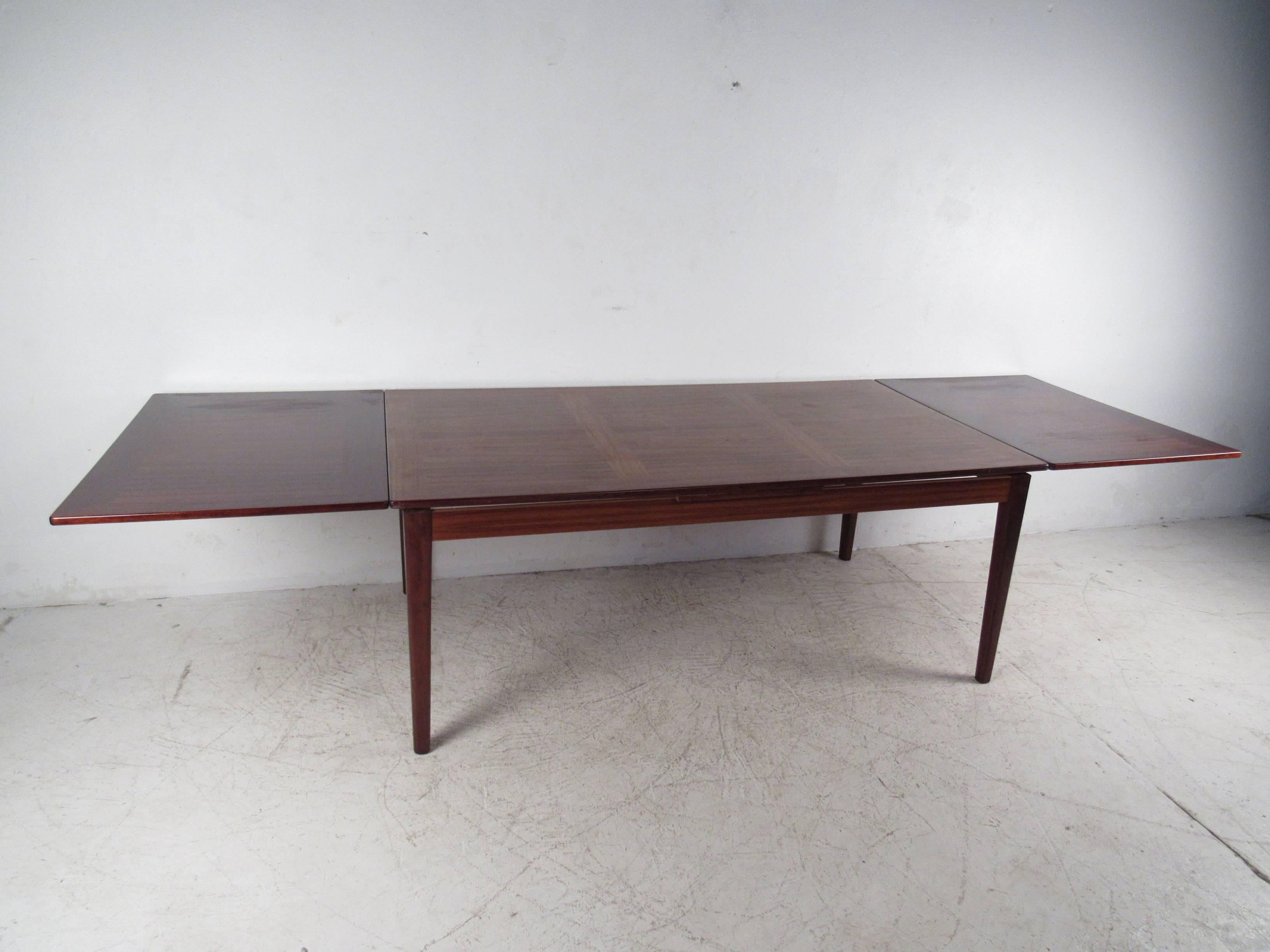 This gorgeous rosewood table has two leaves that spread out extending this table to 126
