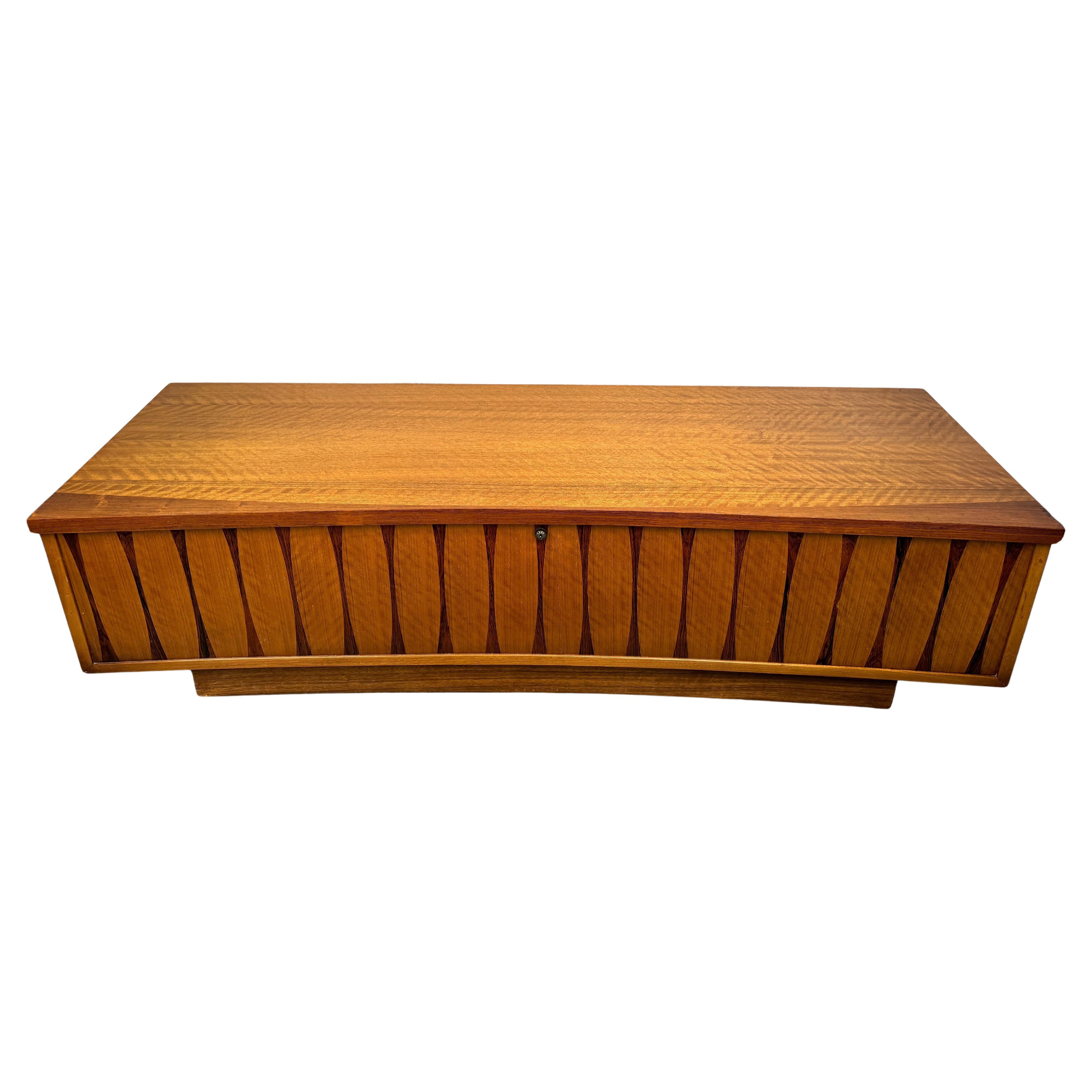 Questa cassapanca intarsiata in stile Mid-Century Modern Lane's è un vero e proprio pezzo forte, che mette in mostra il perfetto connubio tra arte e funzionalità. Realizzata con precisione, la cassapanca presenta uno splendido disegno a intarsio che