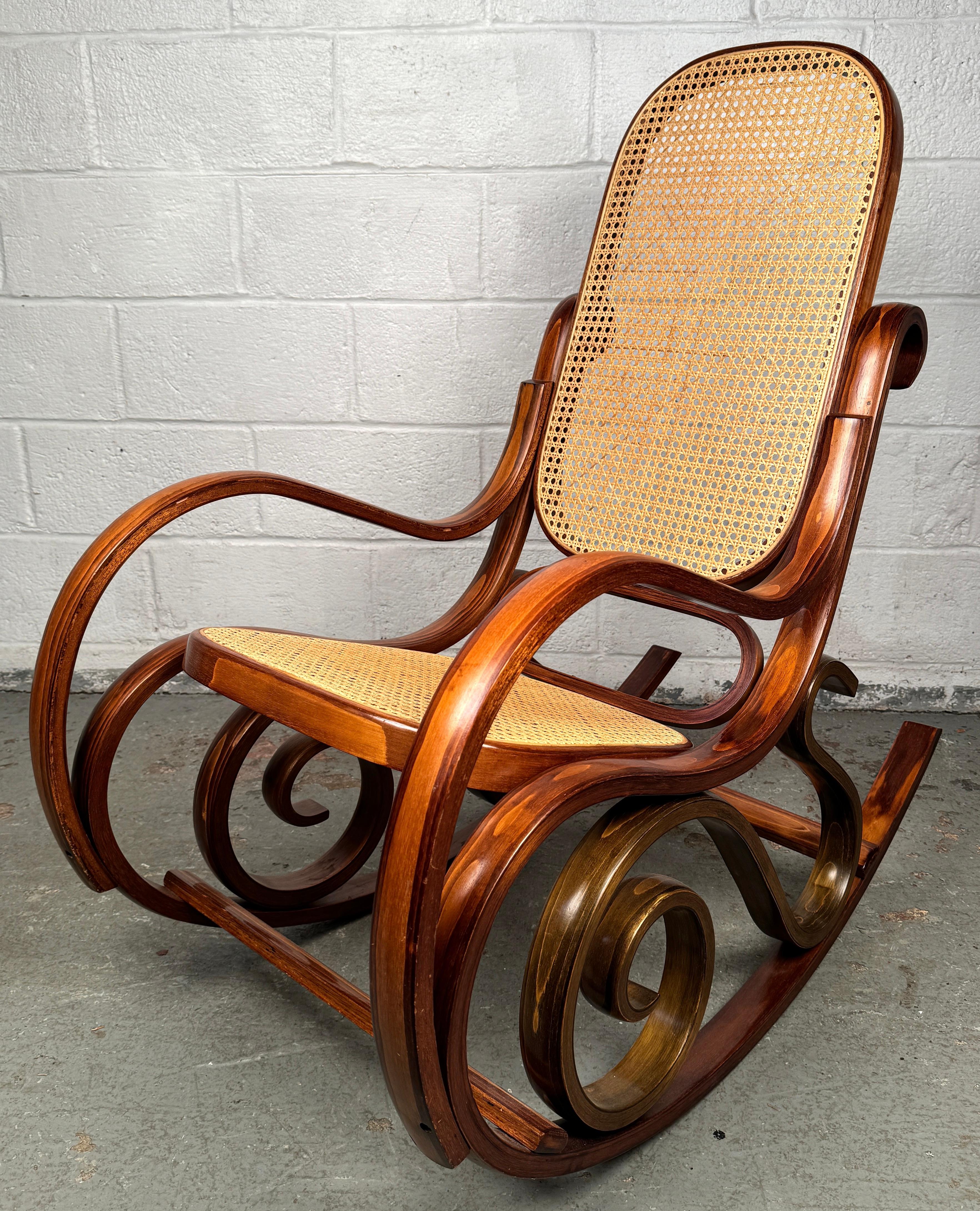 Porta un tocco di charme del Vecchio Mondo nella tua casa con questa elegante sedia a dondolo in legno curvato in stile Thonet, un pezzo vintage che cattura il romanticismo e la maestria del design europeo del XIX secolo. Ispirato all'iconico lavoro