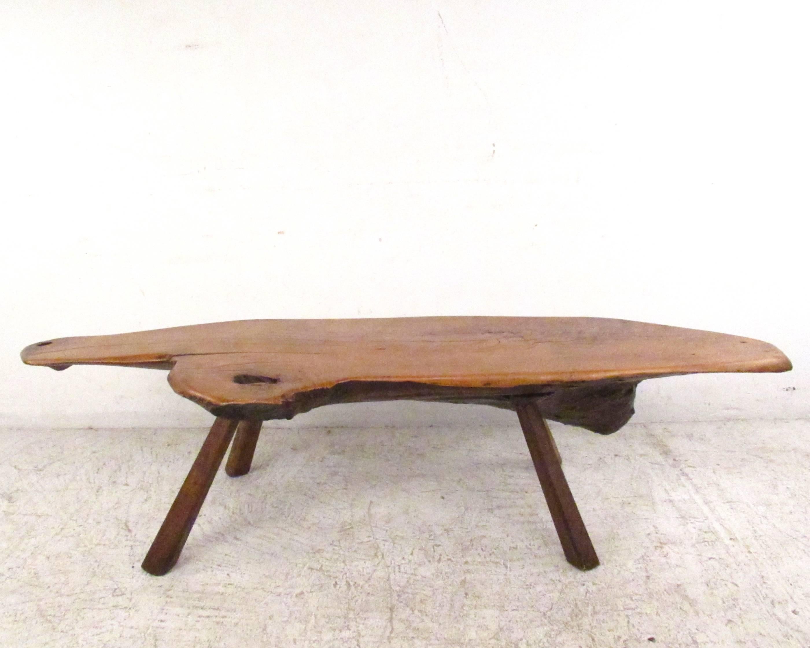 This unique vintage coffee table features a rustic tree slab coffee table with free edge table top. Perfect rustic style table for a variety of interiors. Tapered legs, unique shape, and one of a kind construction make this a beautiful addition to