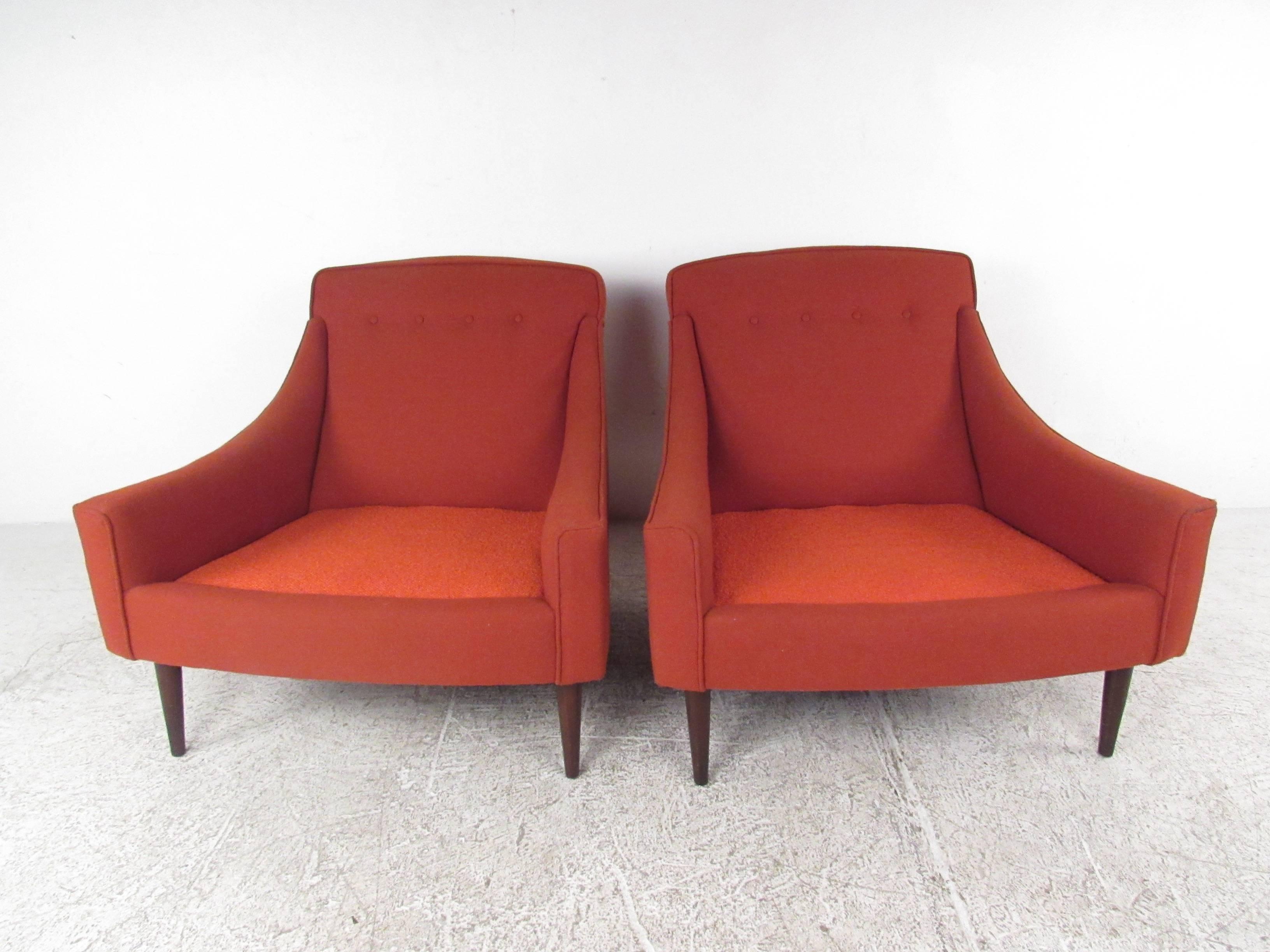 This stunning pair of Danish modern lounge chairs features wide and comfortable seat cushions with sculpted gradual armrests. Tufted upholstery and tapered legs add to the subtle style of this vintage set. Perfect additional seating for home or