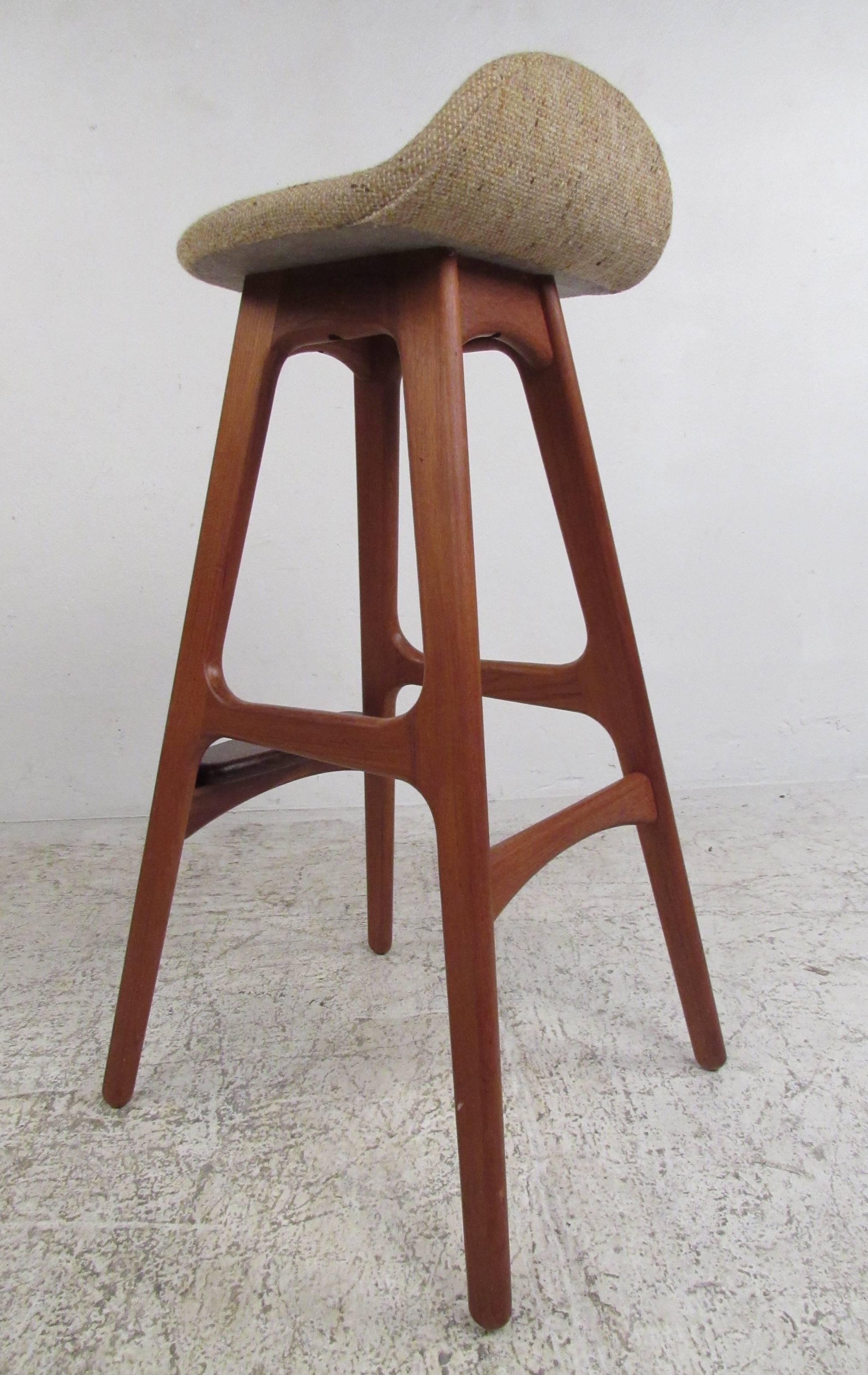 Pair of teak barstools by Erik Buch with upholstered seats and rosewood foot rests. Please confirm item location (NY or NJ) with dealer.
     