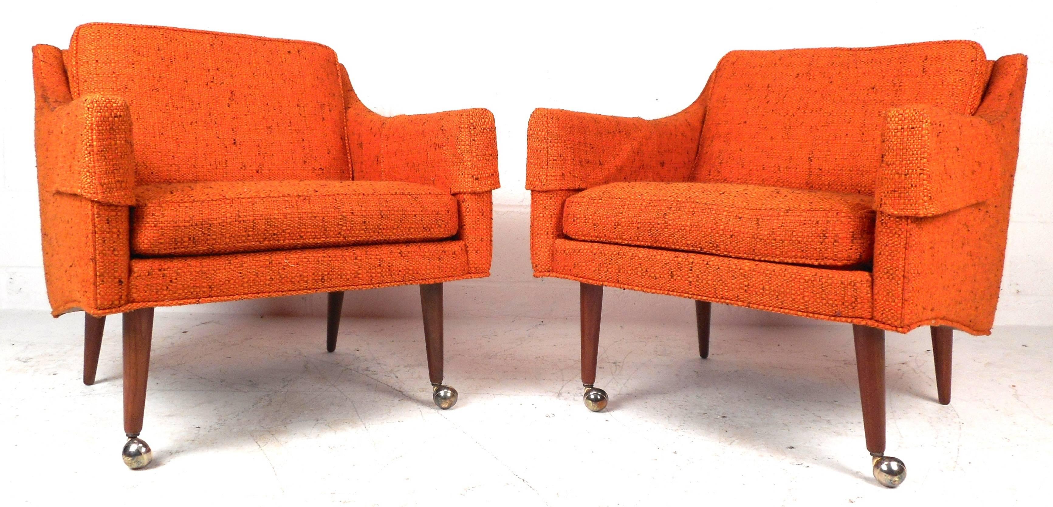 This stunning set of four vintage modern lounge chairs feature wonderful vintage orange upholstery and tapered walnut legs. Sleek design with thick padded removable cushions and stylish low arm rests ensuring maximum comfort. This unique set of four