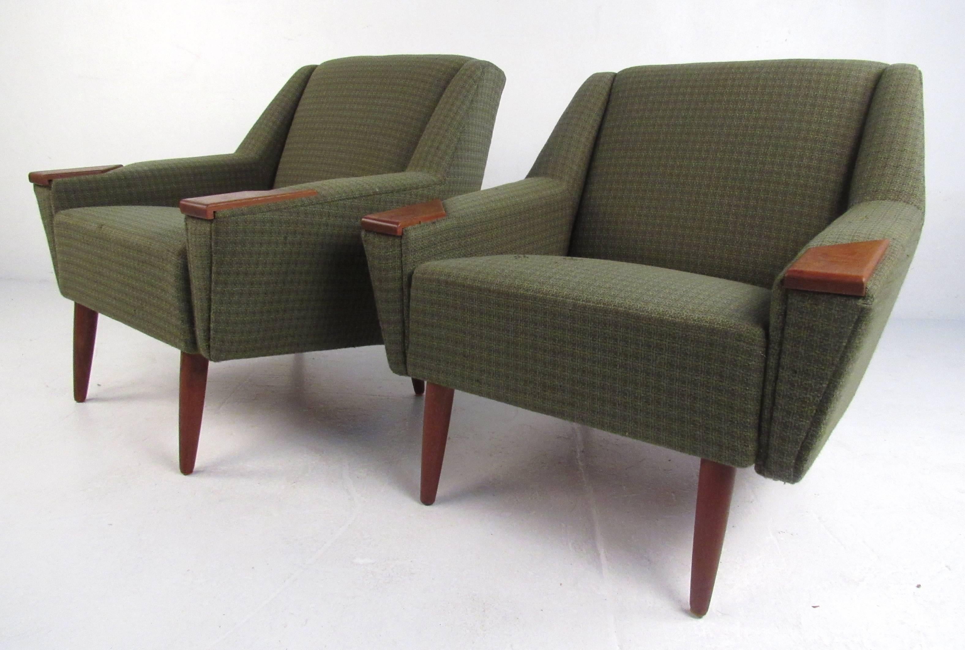 This beautiful pair of vintage modern lounge chairs boast wood tipped arm rests, tapered walnut legs, and a lovely green upholstery. The angled back rest and thick padded seating offer maximum comfort. A sleek and sturdy design that is sure to make