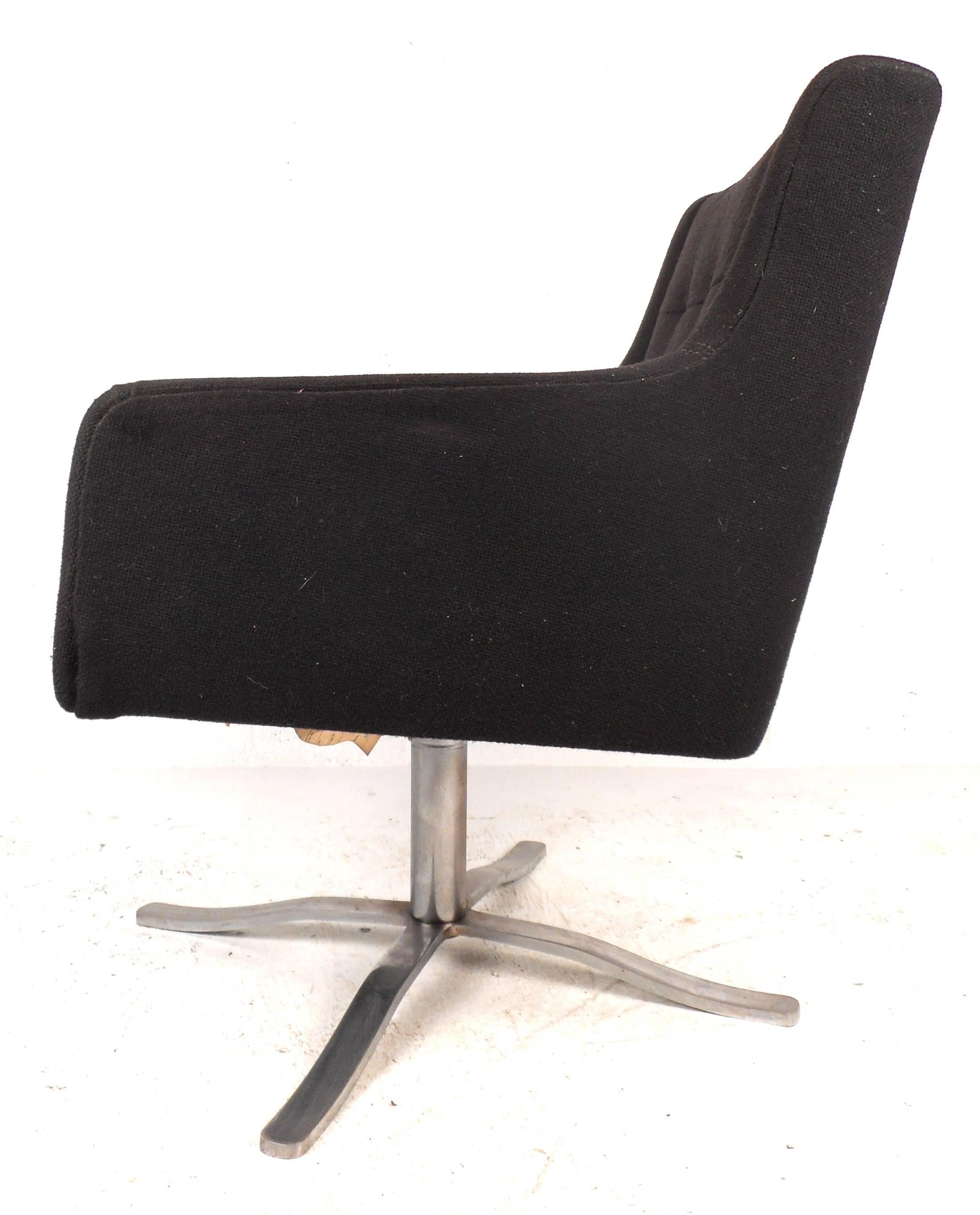 Lovely Mid-Century lounge chair features a tufted backrest, heavy chrome swivel base, and vintage black stitched upholstery. Unique yet simple design provides comfort and style in any interior. Please confirm item location (NY or NJ).