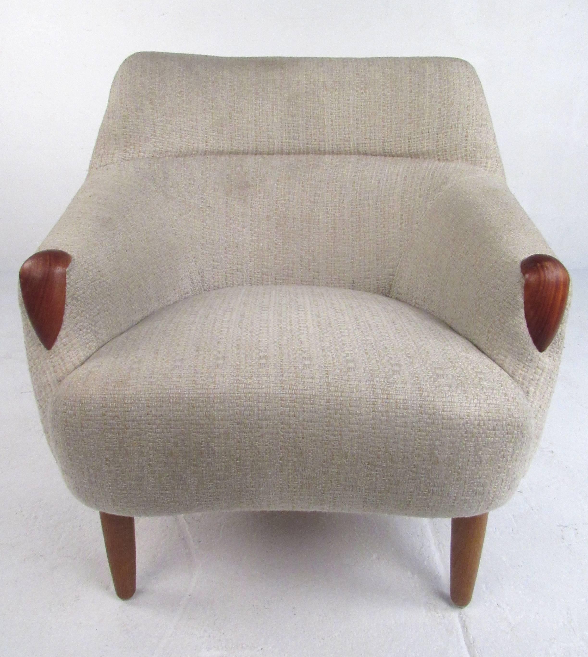 Unique upholstered Kurt Ostervig influenced lounge chair with teak tapered legs and hand rests. Please confirm item location (NY or NJ) with dealer.