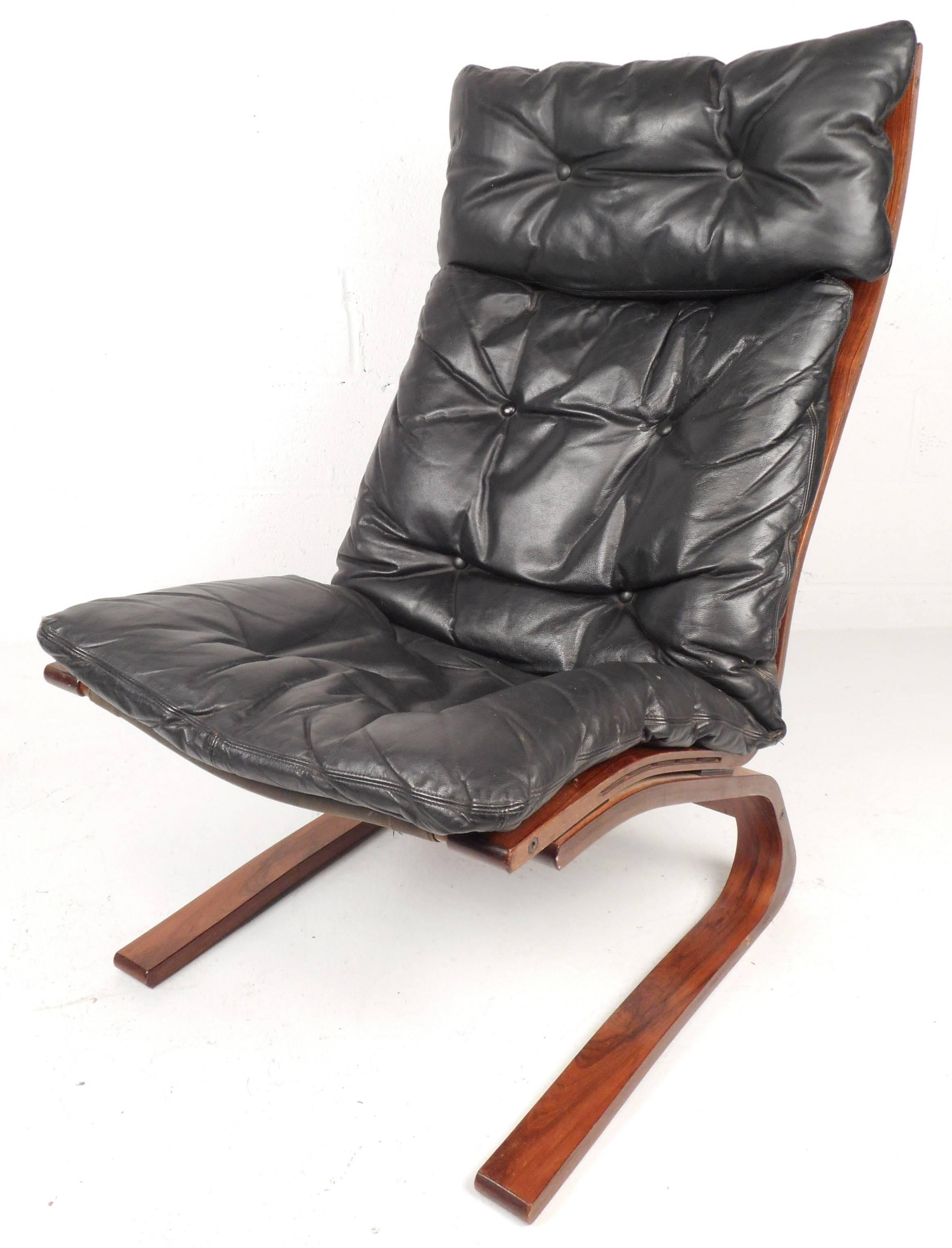 Stunning modern Ingmar Relling lounge chair and ottoman features a bent rosewood frame and tufted vintage leather. Unique design provides comfort without sacrificing style making it perfect for any interior. The ottoman's dimensions: 23.5 W 21 D 15