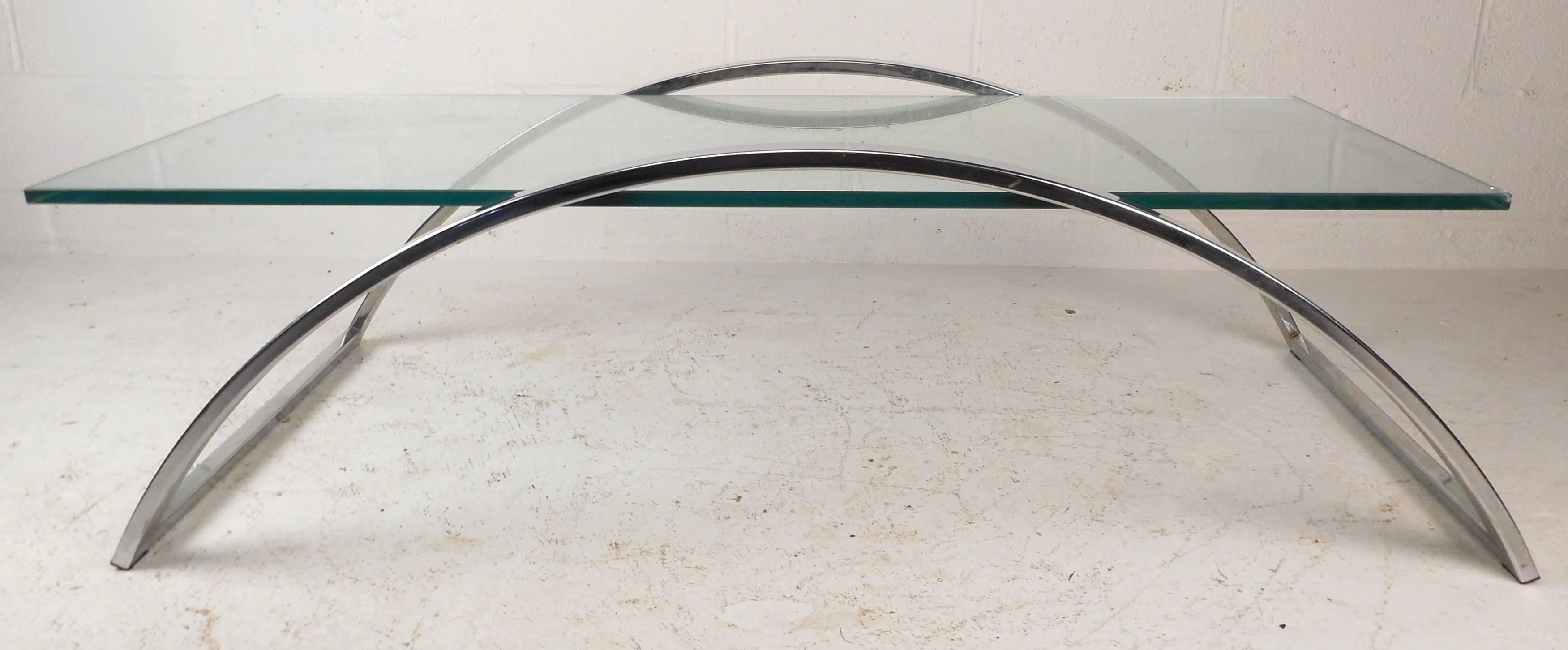 This stunning Mid-Century Modern coffee table features an arched frame of heavy chrome with a thick glass top. The unique base compliments the floating glass top, providing a stylish vintage look great for any setting. Please confirm item location