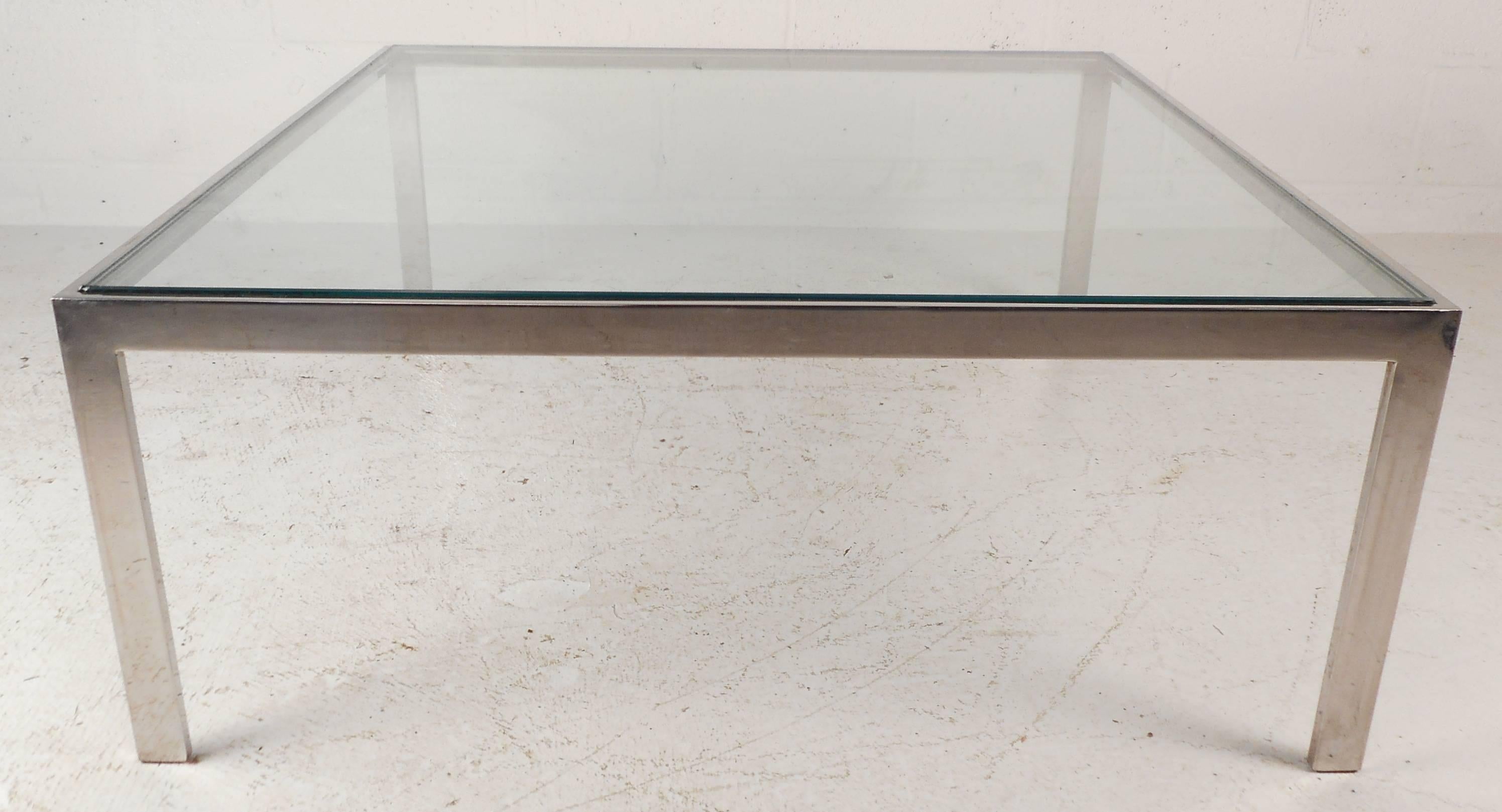 The simple yet elegant lines on this Mid-Century Modern chrome coffee table make a stylish addition to any seating area. Featuring a heavy chrome frame and a thick square glass top, the unique design makes an impressive and sturdy table for any