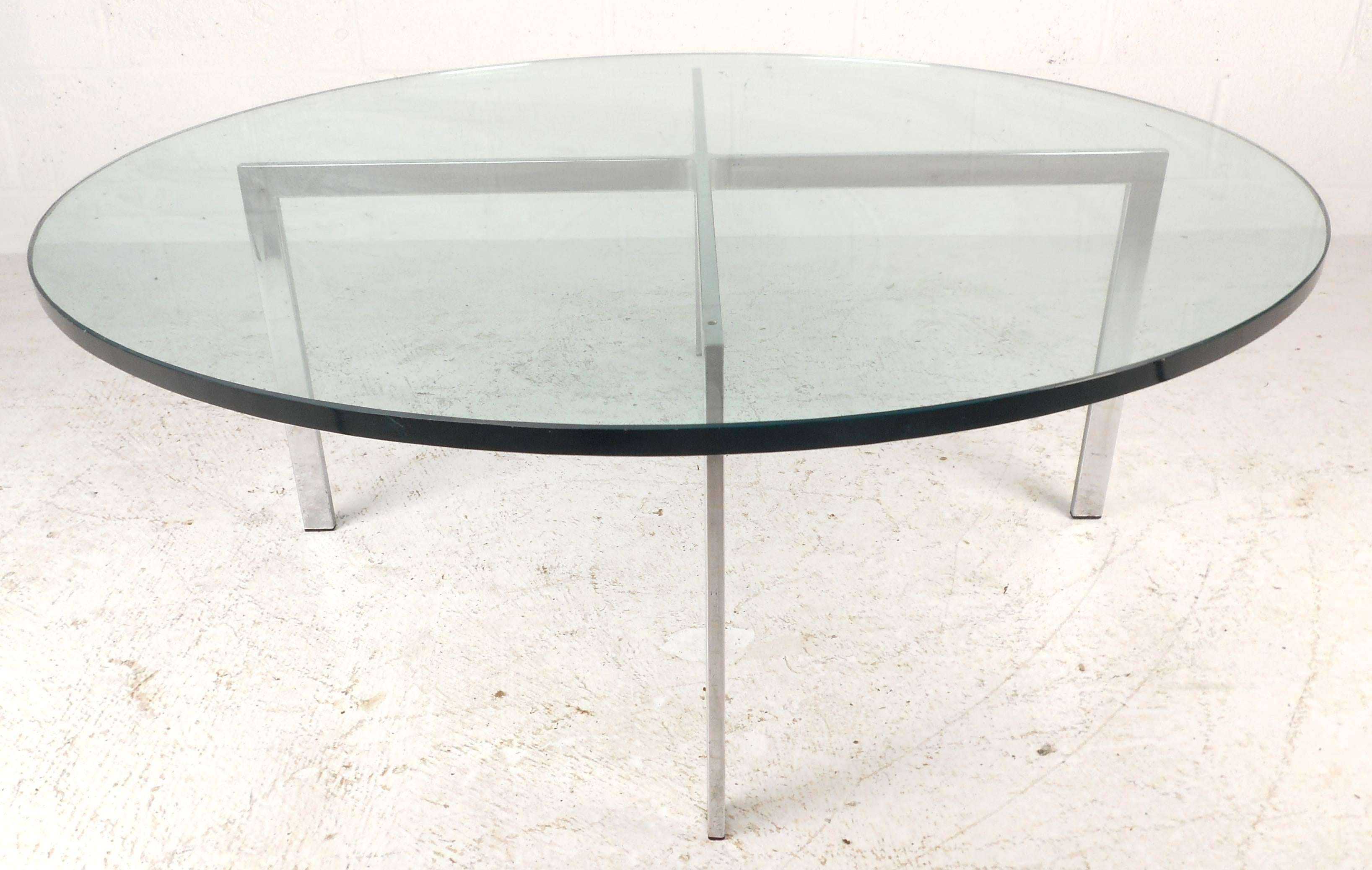 This vintage modern circular coffee table features a heavy "X" shaped base with 1" thick green glass. The unique design assures sturdiness without sacrificing style in any interior, making a fantastic Mid-Century Modern addition to