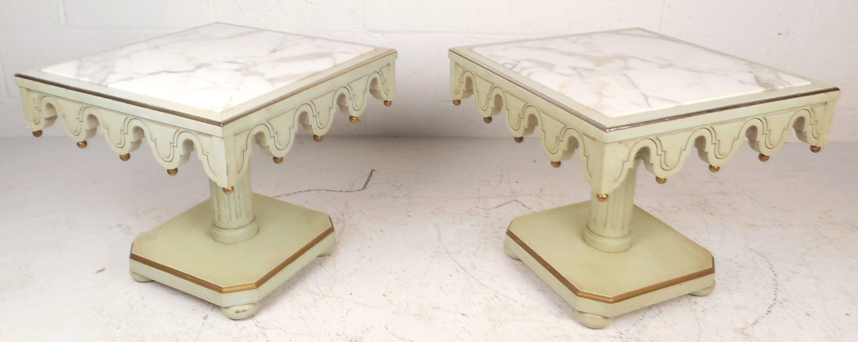Wonderful pair of Mid-Century Hollywood Regency style end tables featuring unique sculpted and etched draping designs around a white marble top. Unique fluted centre pedestal supports and decorative brass hanging fixtures add style and grace to any
