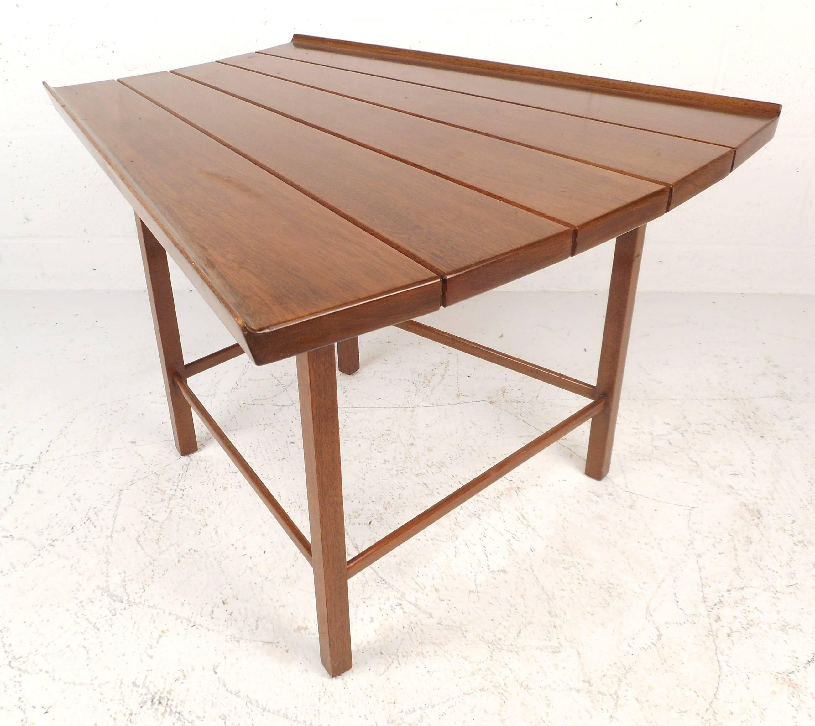 Gorgeous vintage modern slat bench/end table is made of solid walnut and features a uniquely shaped top with raised edges. The vintage walnut finish and stylish stretchers on the legs show quality craftsmanship. A versatile piece that offers various