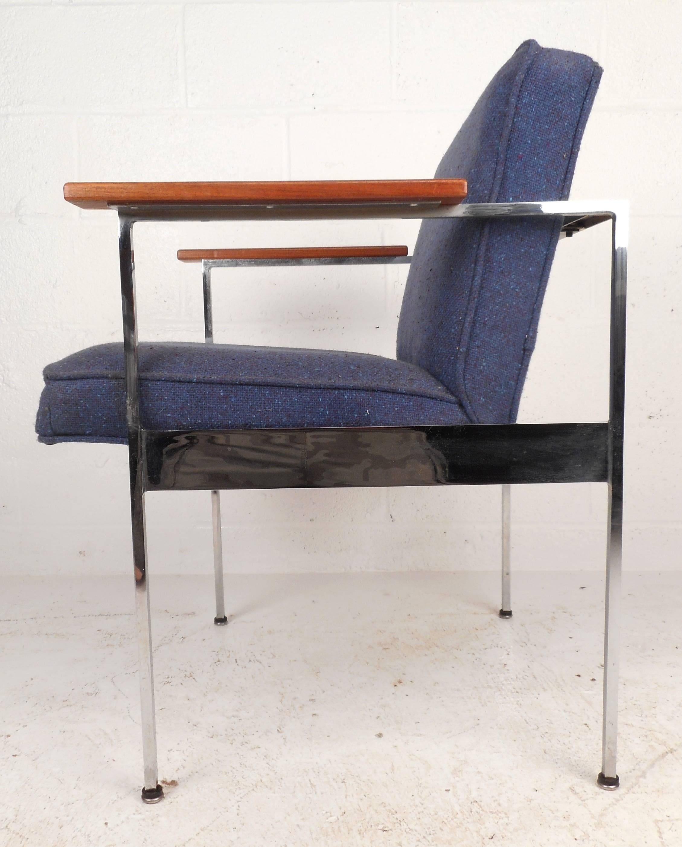 Stunning vintage modern armchair features soft vintage royal blue upholstery and wide wooden armrests. The sleek chrome frame ensures sturdiness without sacrificing comfort, stylish. Please confirm item location (NY or NJ).