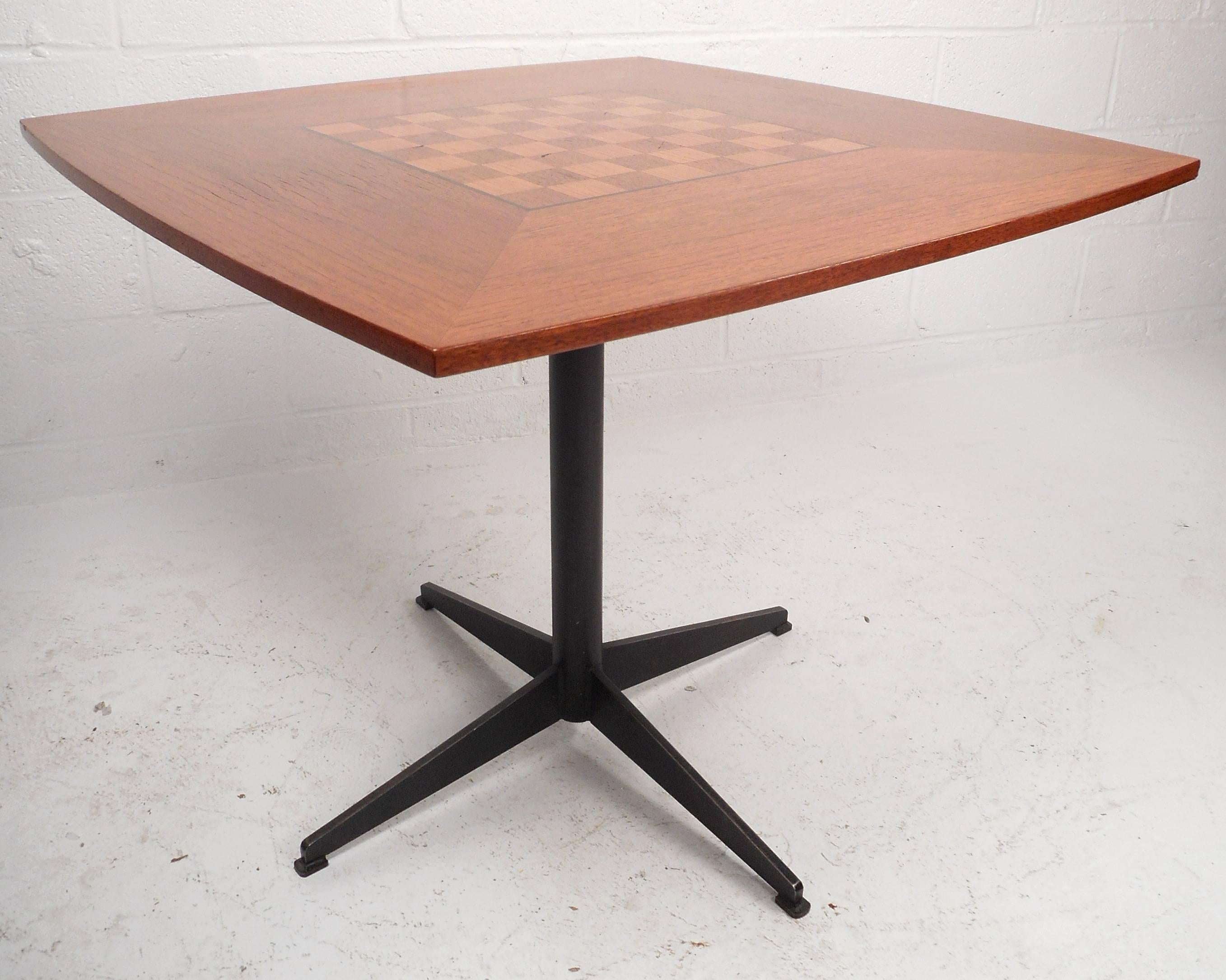 Stylish vintage modern game table features an inlaid game table in the center and a sturdy black metal base. The unusual smooth rounded sides as opposed to the simple square look add to the allure. The beautiful vintage teak finish makes it the