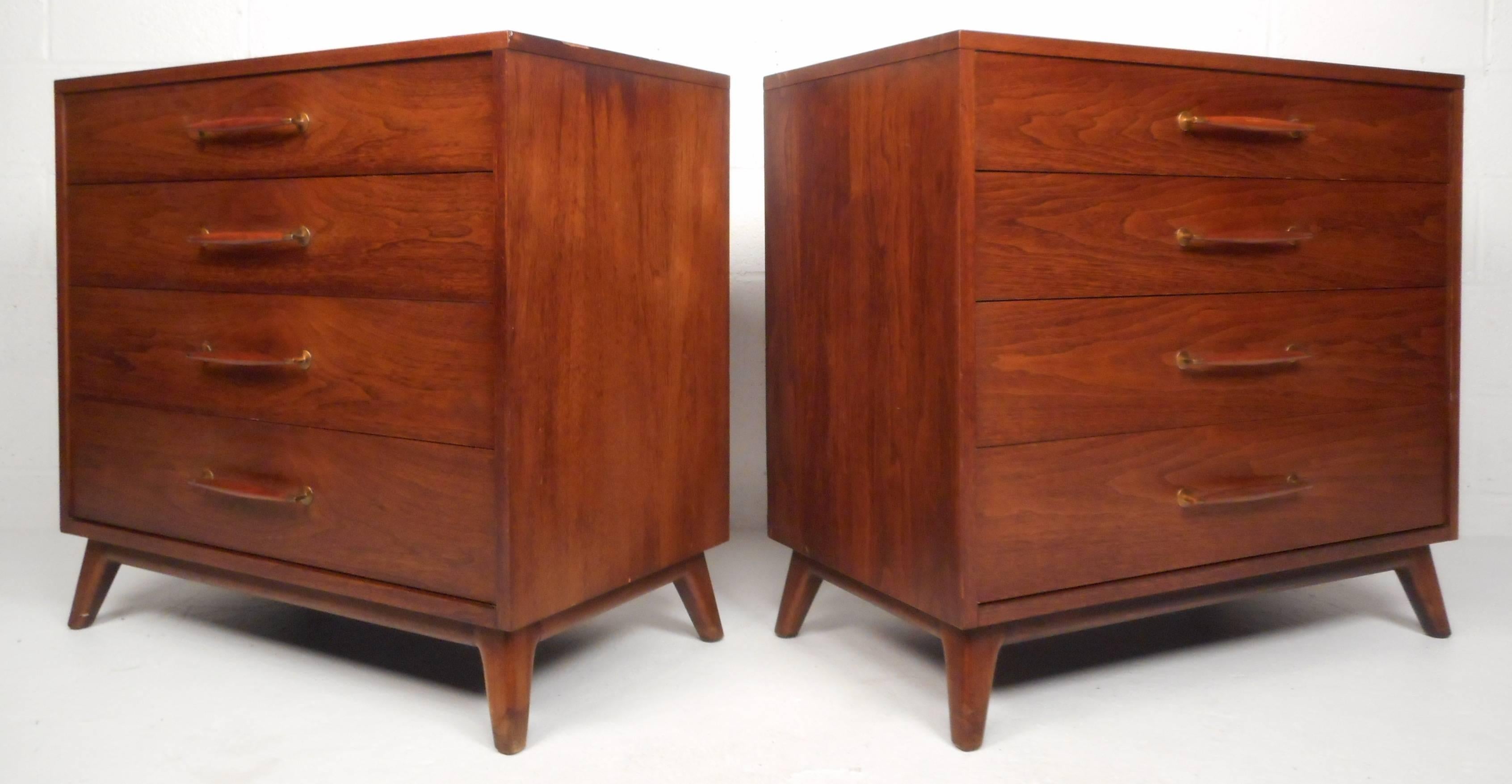 Well-designed pair of vintage modern dressers by Henredon feature four dovetailed drawers, wood handles with brass fixtures, and two vertical mahogany inlay strips on top. Stylish and sturdy construction with sleek, modern design. Please confirm