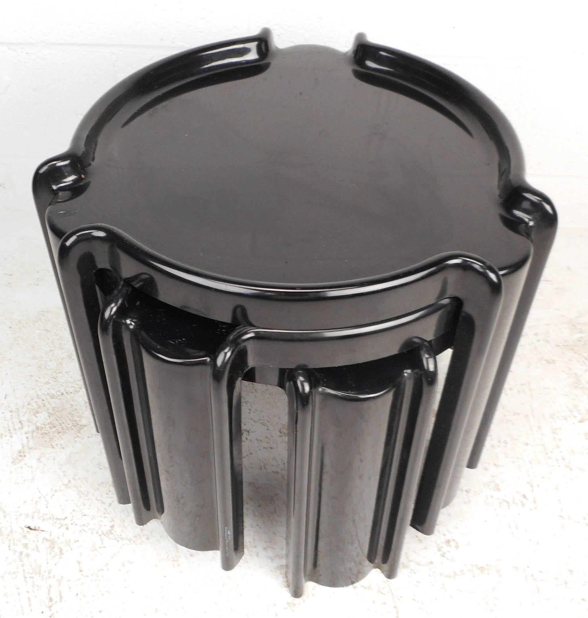 Wonderful set of three vintage modern nesting tables with unique molded design allowing them to fit easily on top of one another. Sleek jet black color with rounded raised edges and space saving ability. Perfect addition to any modern interior.