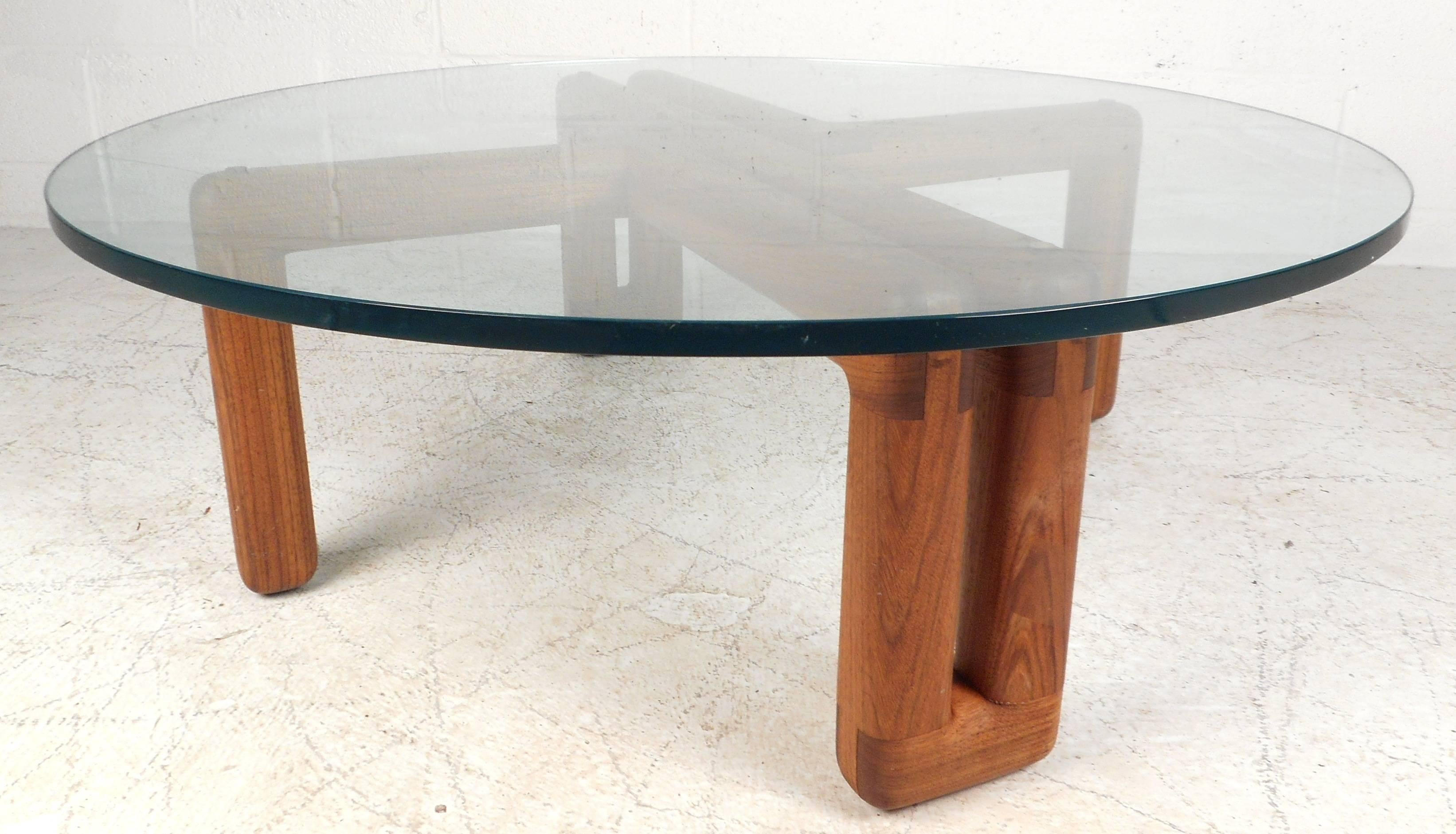 Beautiful vintage modern glass coffee table features a unique solid walnut base with dovetailed joints. The stylish tubular style base provides sturdiness underneath a 1" thick round glass top. Perfect addition to any home, business, or office.