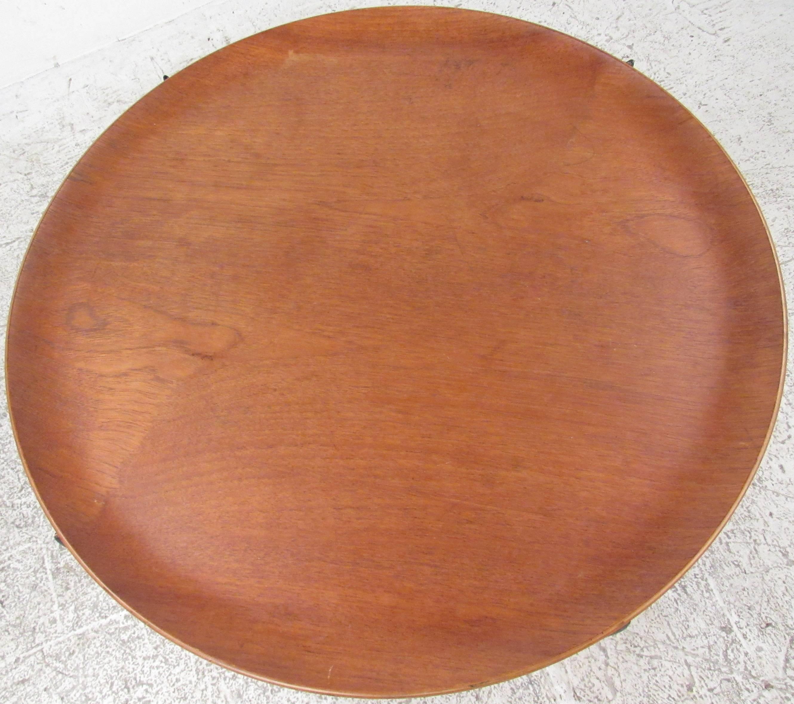 Collapsible circular teak tray table on black ebonized base. Please confirm item location (NY or NJ) with dealer.