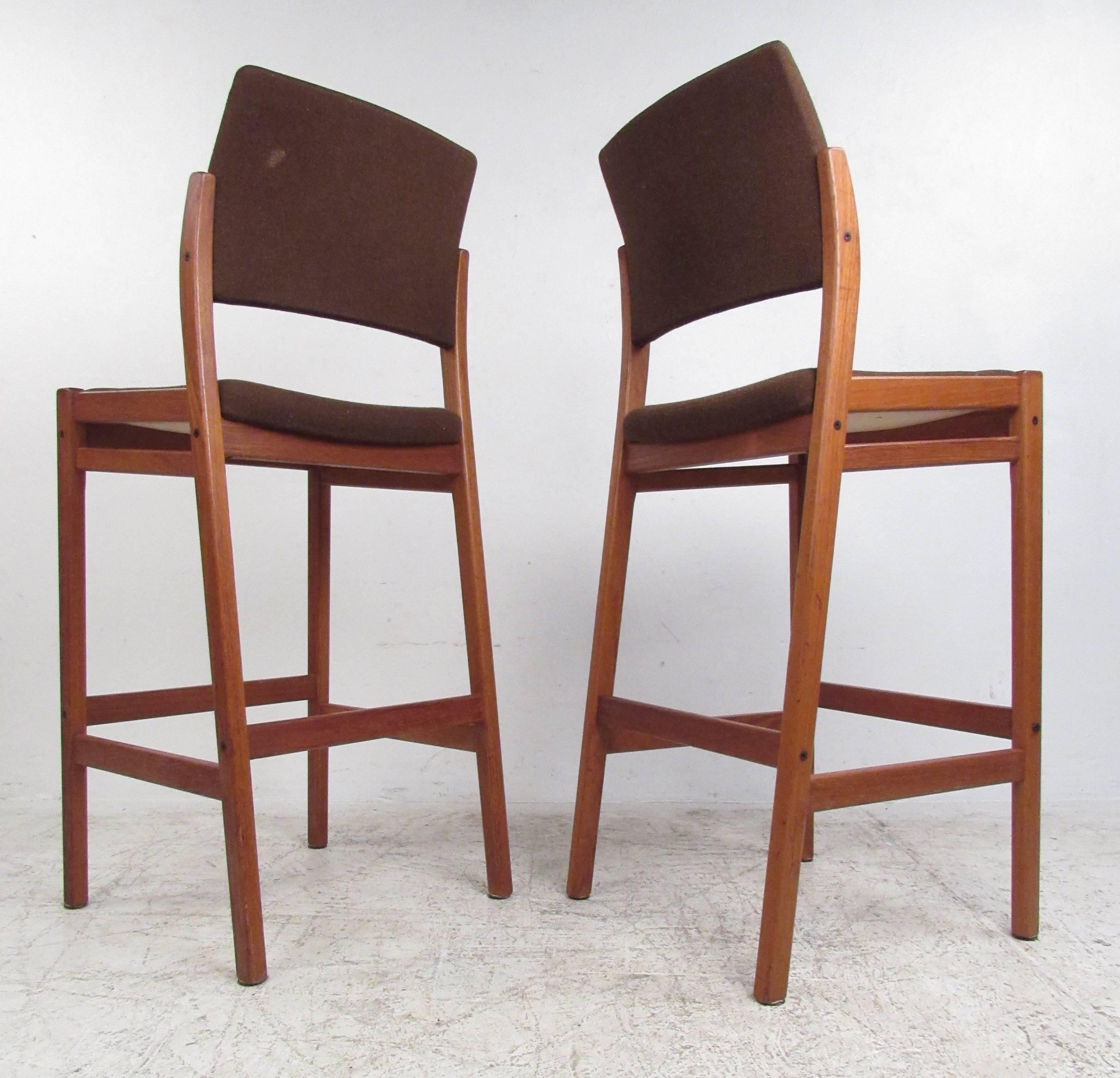 Danish modern upholstered bar stools with teak frames.