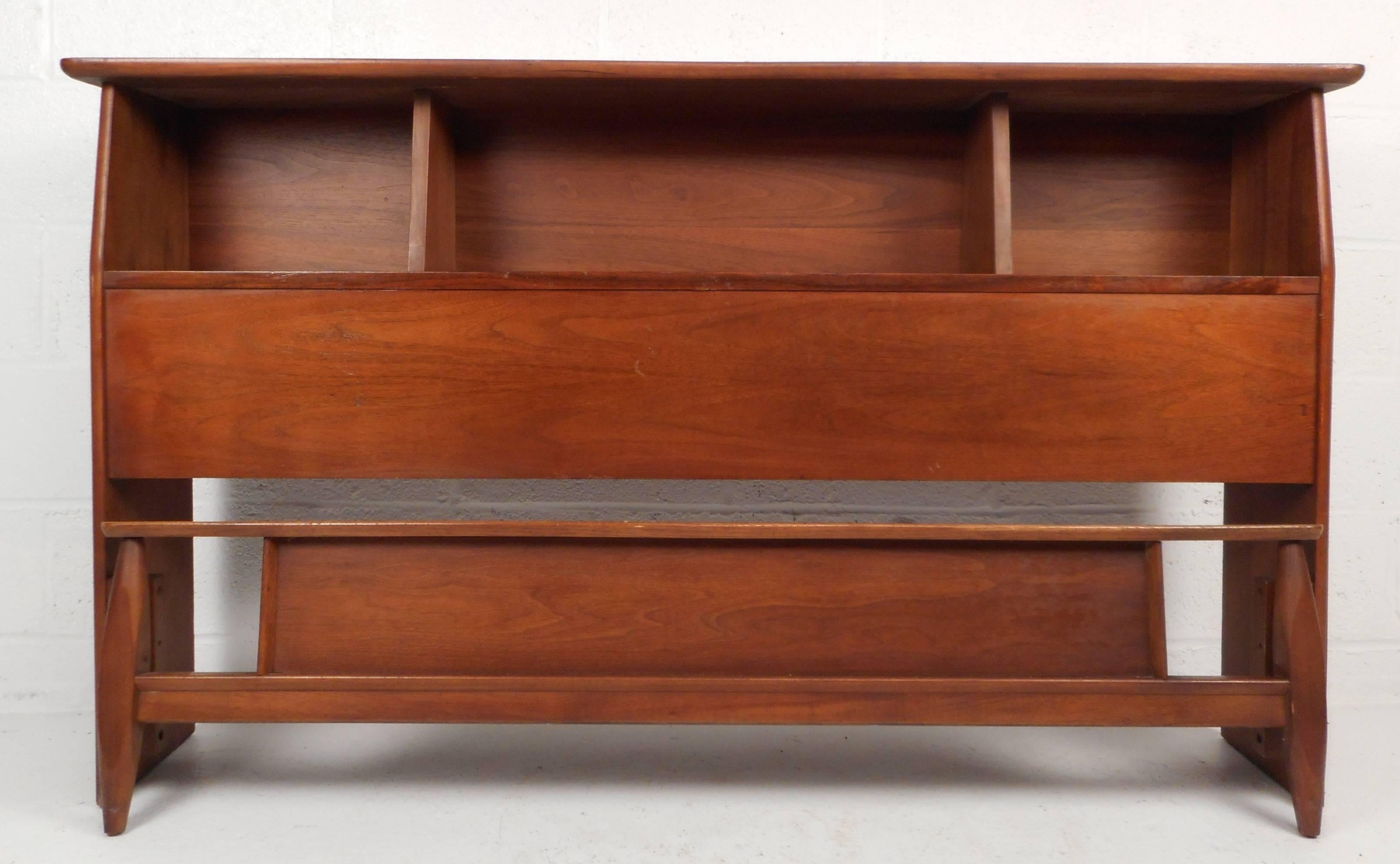 This impressive Mid-Century Modern queen-size headboard and footboard feature a vintage walnut finish. The beautiful headboard offers plenty of room for storage in its three large compartments on top. The sleek top with rounded edges and a footboard