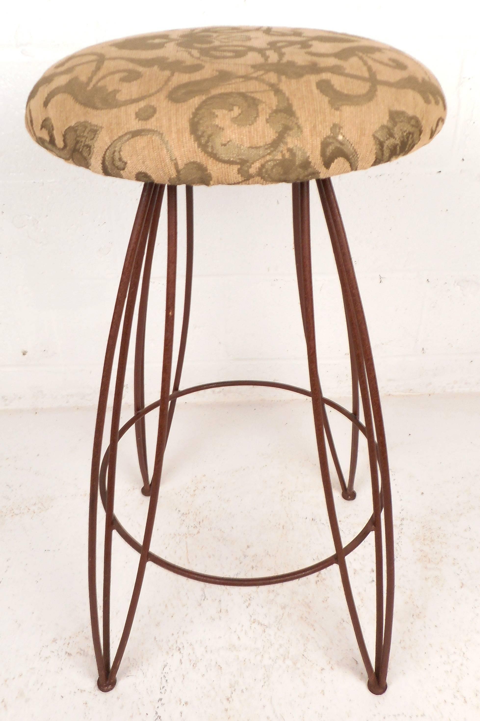 Beautiful set of three vintage modern bar stools feature a comfortable round upholstered seat on top of a sturdy wrought iron base. The unique three prong style hairpin legs and gorgeous design on the fabric add style and grace to any modern