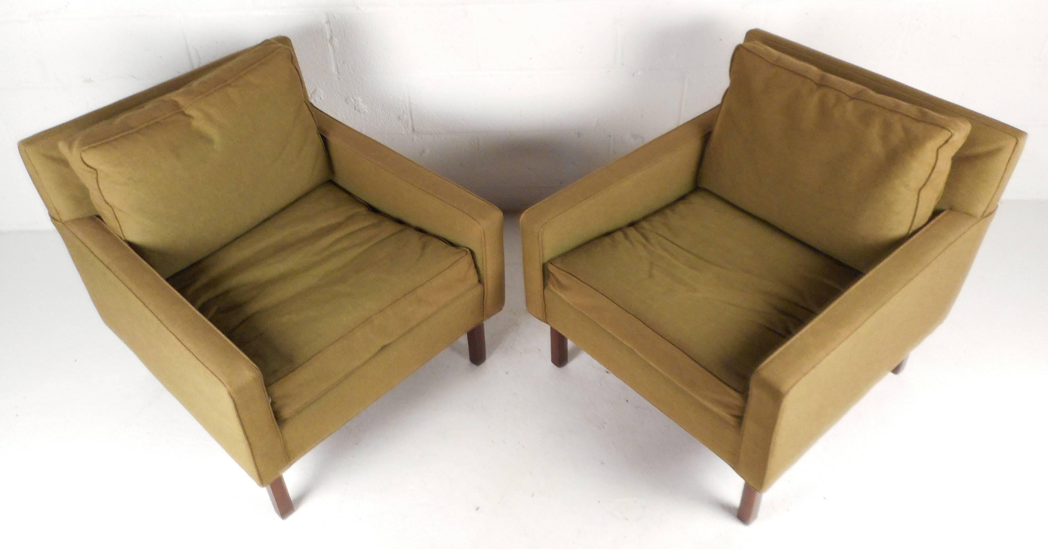 Gorgeous pair of vintage modern lounge chairs with plush green upholstery and a solid walnut base. Sleek design features low arm rests and thick cushions ensuring comfort in any setting. The wide seating and stylish shape make them perfect for any