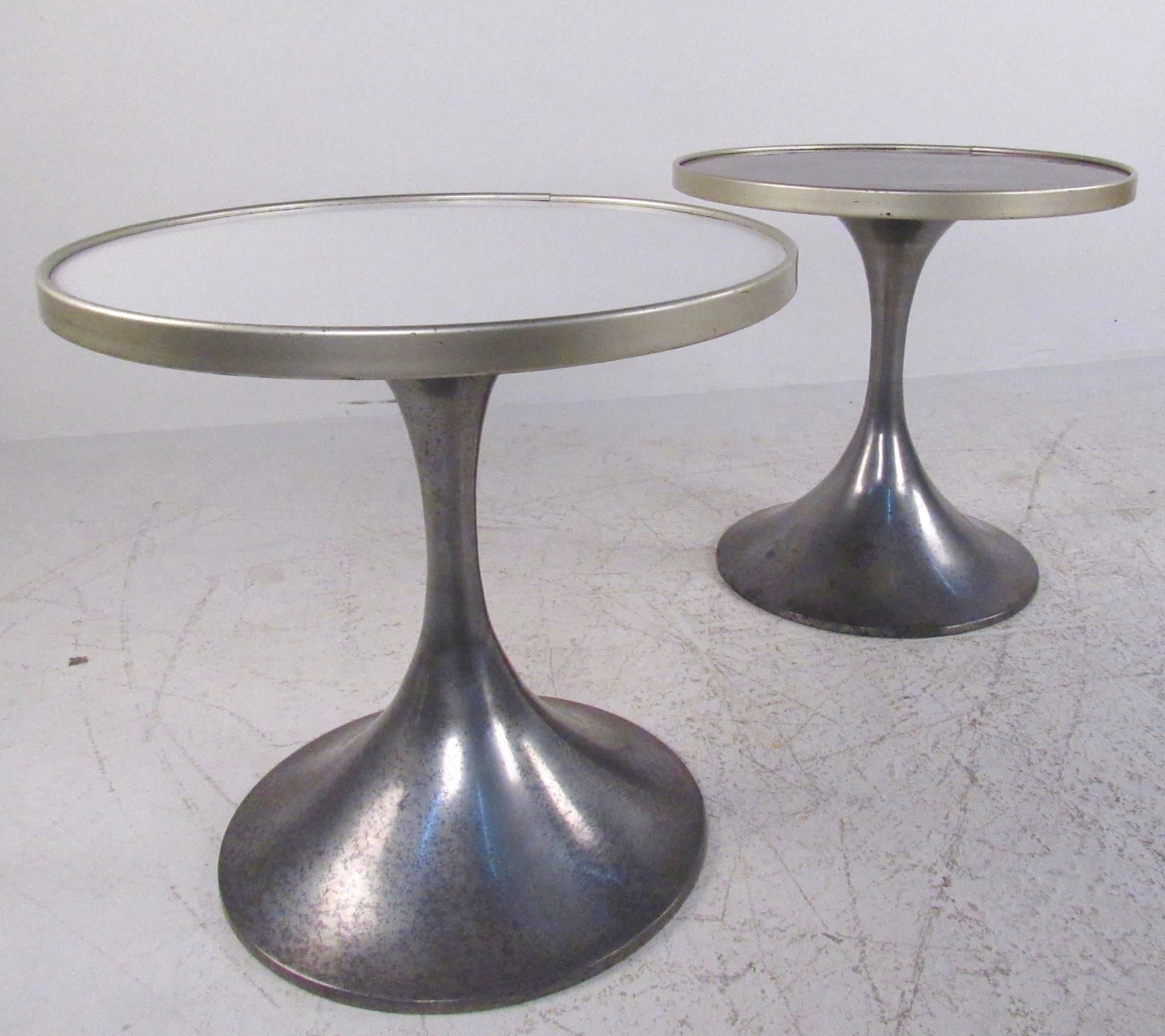 This unique Mid-Century pair features sleek metal pedestals with laminate tops. In complimentary natural wood and white finishes this matching pair of German-made tables echo the style of Eero Saarinen and other Mid-Century Modern icons. These
