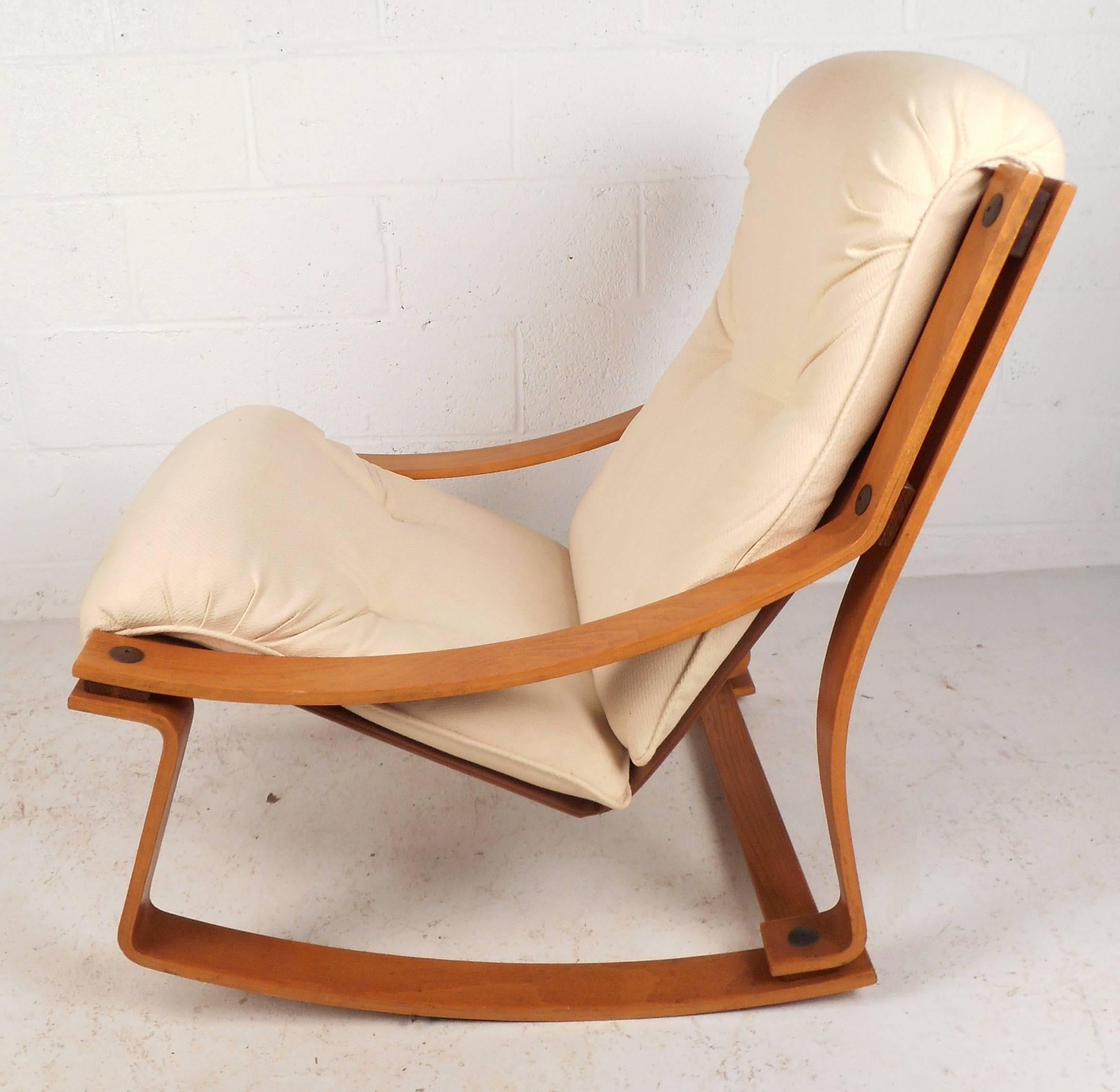 Beautiful vintage modern rocking chair features a bent plywood teak frame and plush white upholstery. Sleek design ensures comfort without sacrificing style in any modern interior. Please confirm item location (NY or NJ).