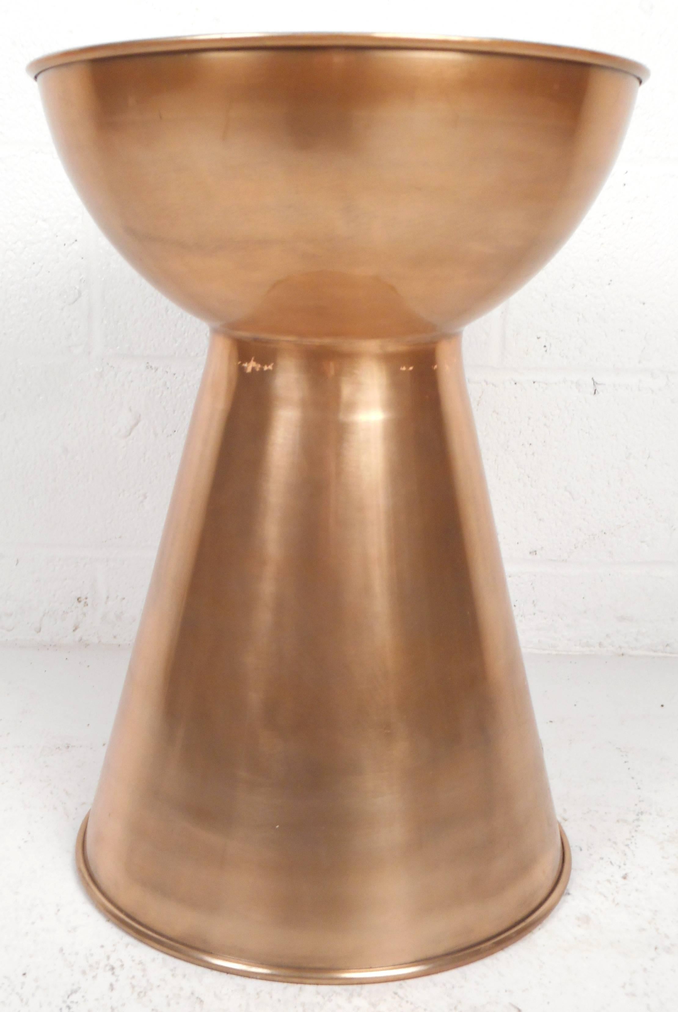 Stunning contemporary modern pedestal features a sculpted hourglass design. The genuine copper finish and sleek design make it the perfect addition to any modern interior. Versatile design can be used as accent table or simply a decorative piece.